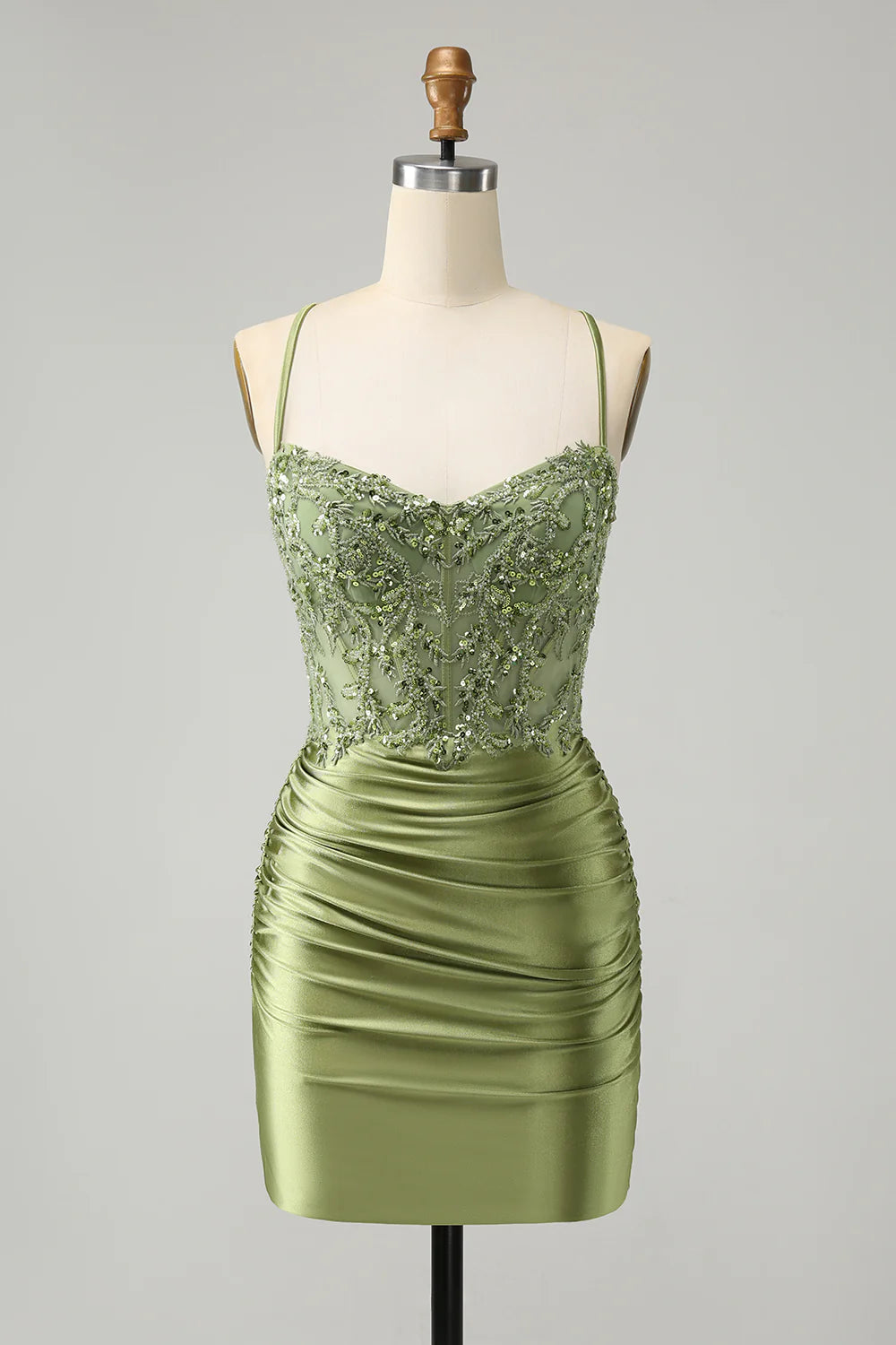 Model wearing a sparkly light green A-line homecoming dress with spaghetti straps and sequin corset.