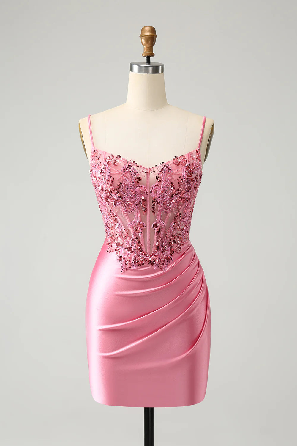 Sparkly pink A-line homecoming dress with glitter, sequins, spaghetti straps, and a pleated corset.