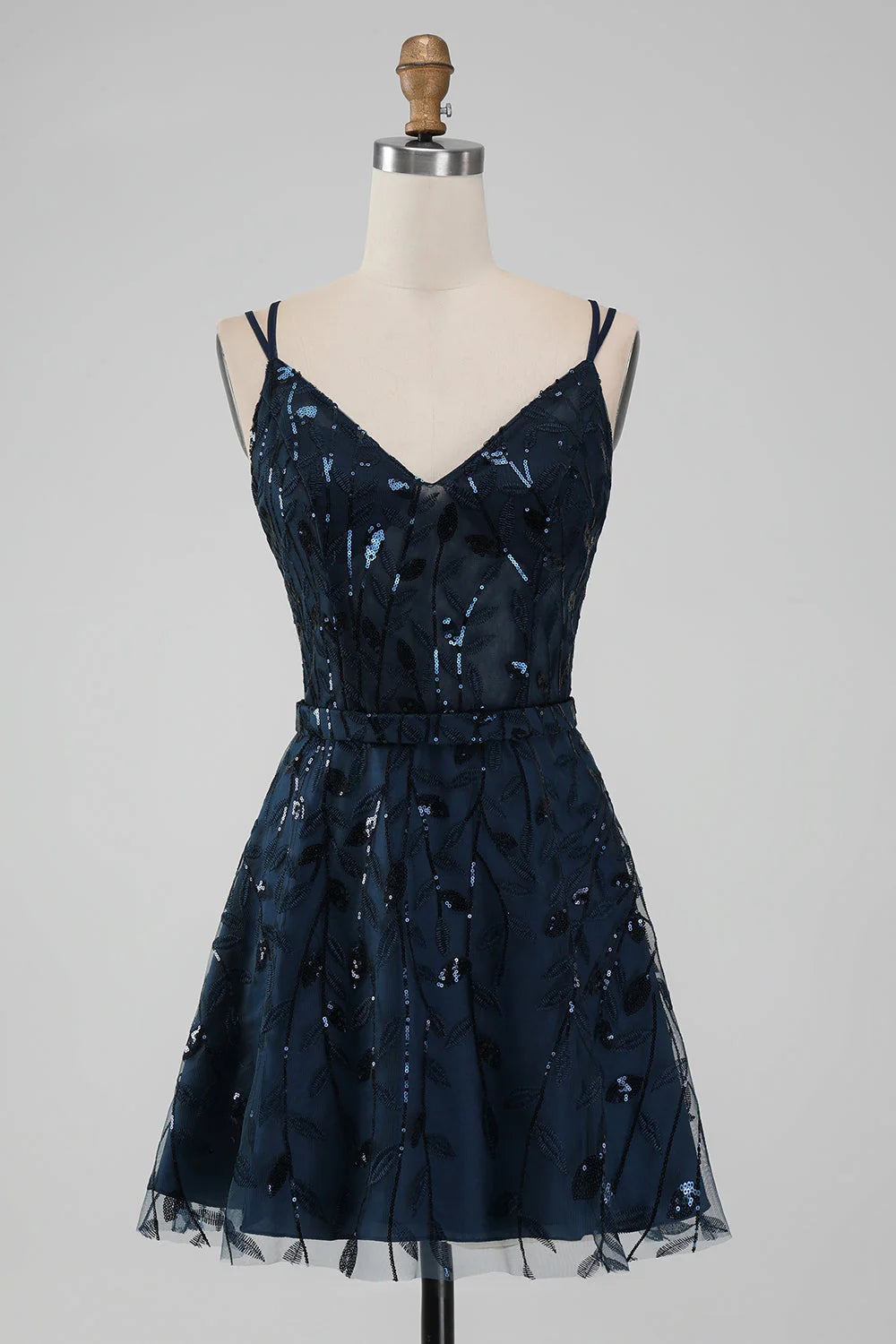 Model wearing a sparkly navy A-line short homecoming dress with spaghetti straps.