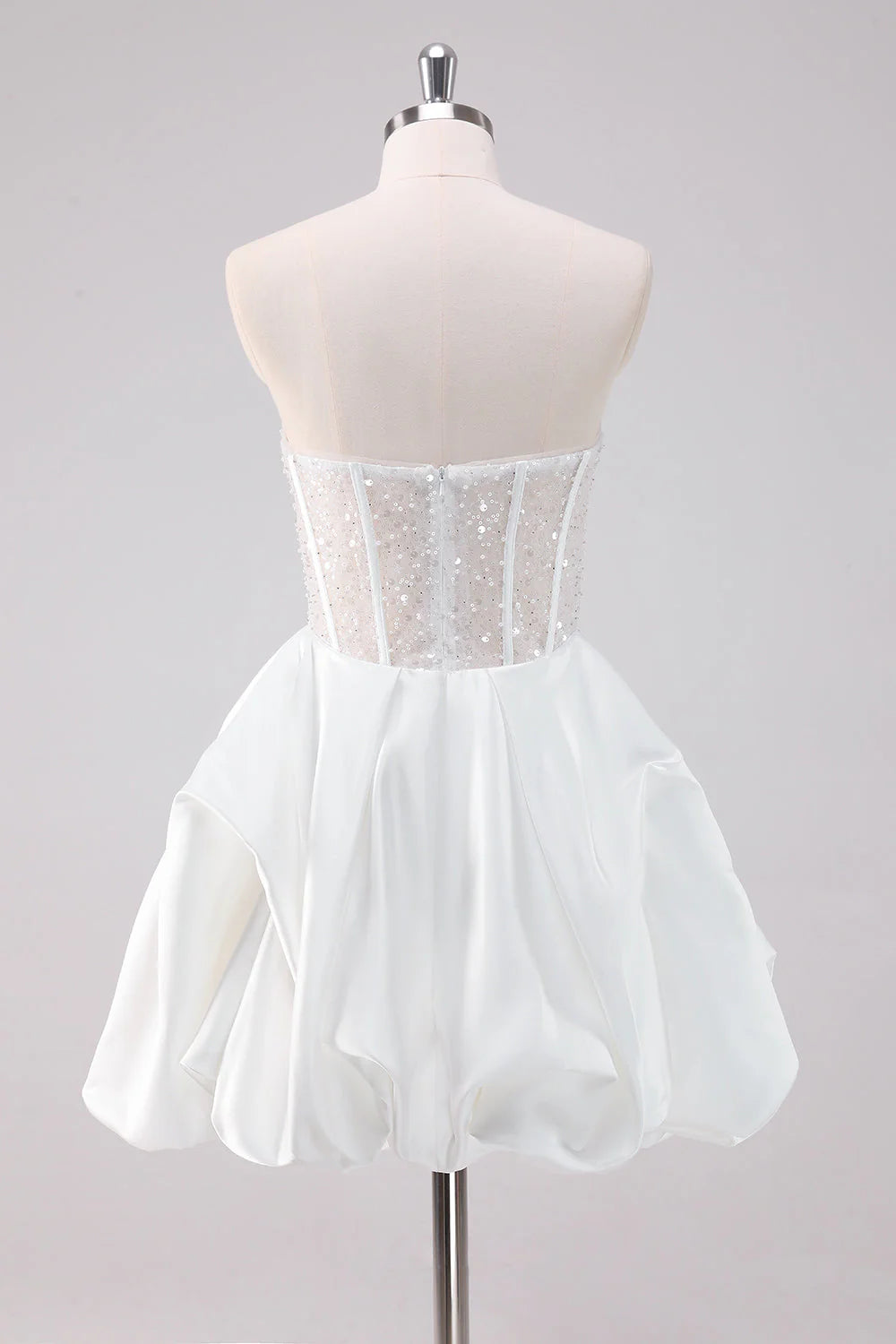 Back view of a model in a sparkly white A-line strapless corset short homecoming dress.