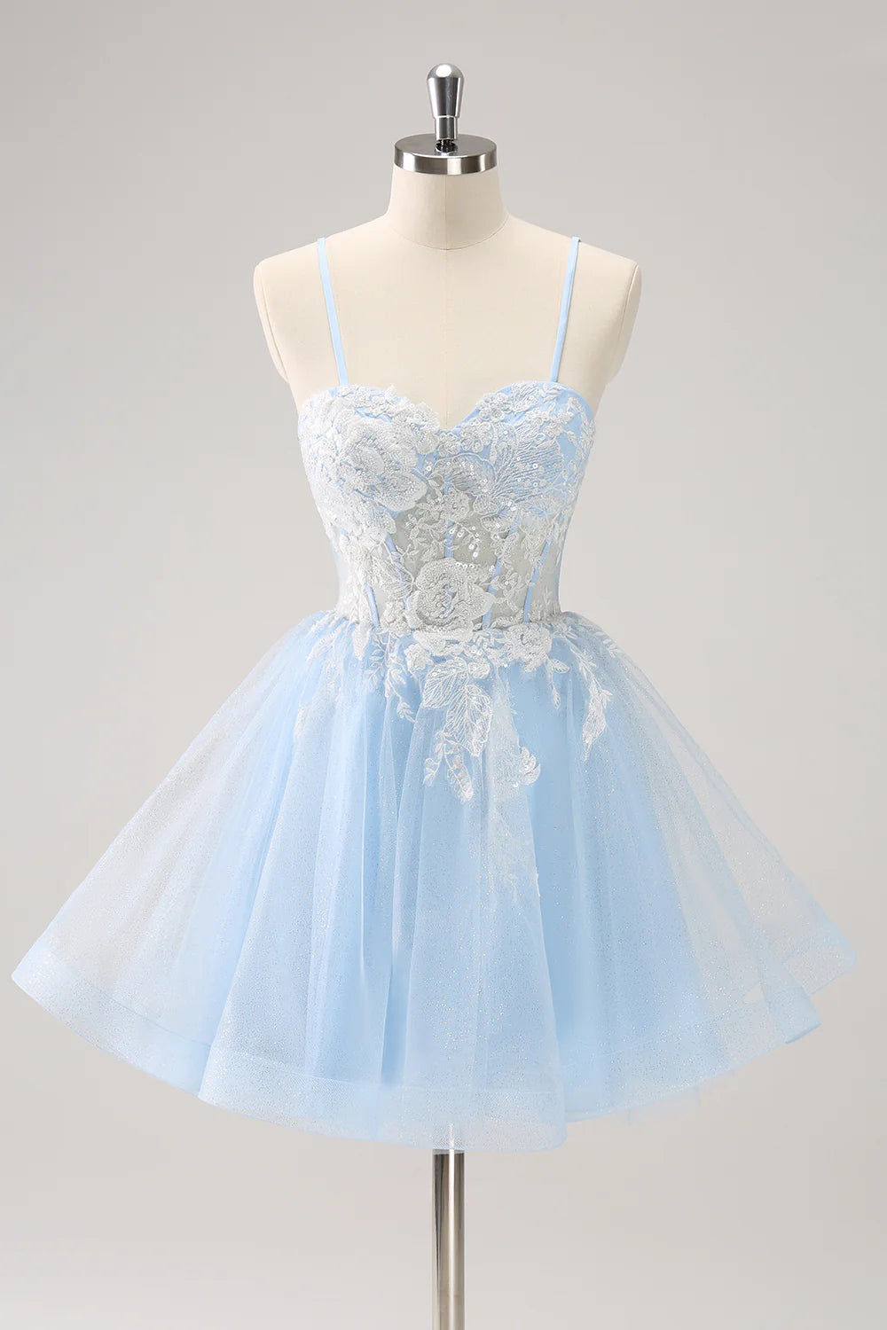 Model wearing a sparkly blue A-line short homecoming dress with sequins and appliques.