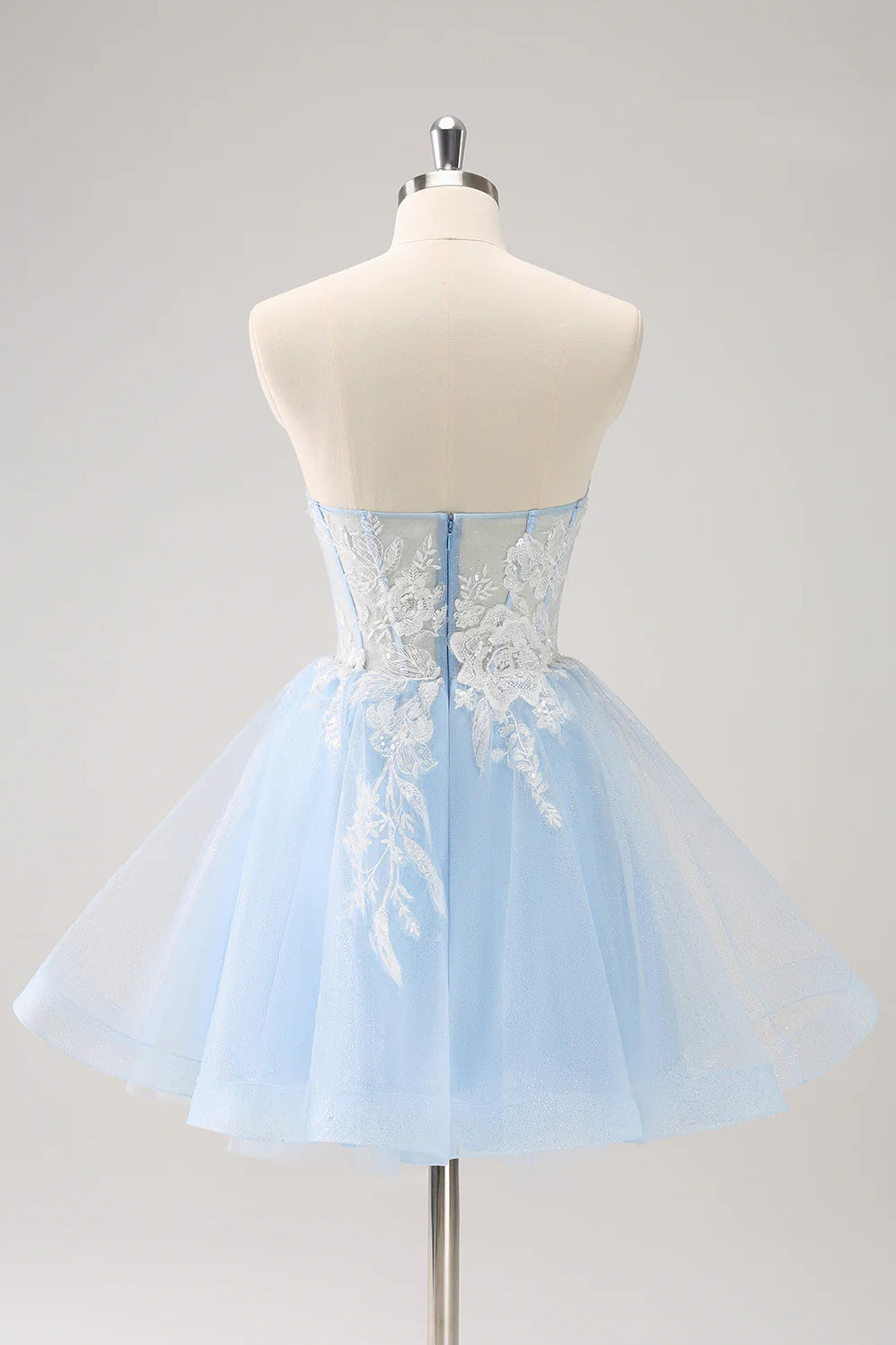 Close-up of the sparkly blue A-line dress showing sequin and applique details.