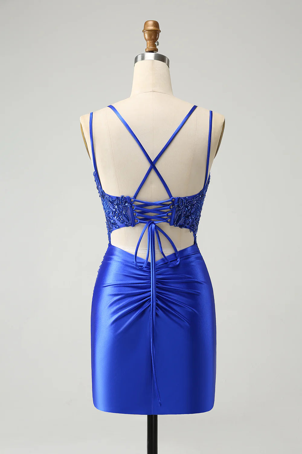Side view of the model showcasing the flowing A-line skirt and beaded details of the royal blue dress.