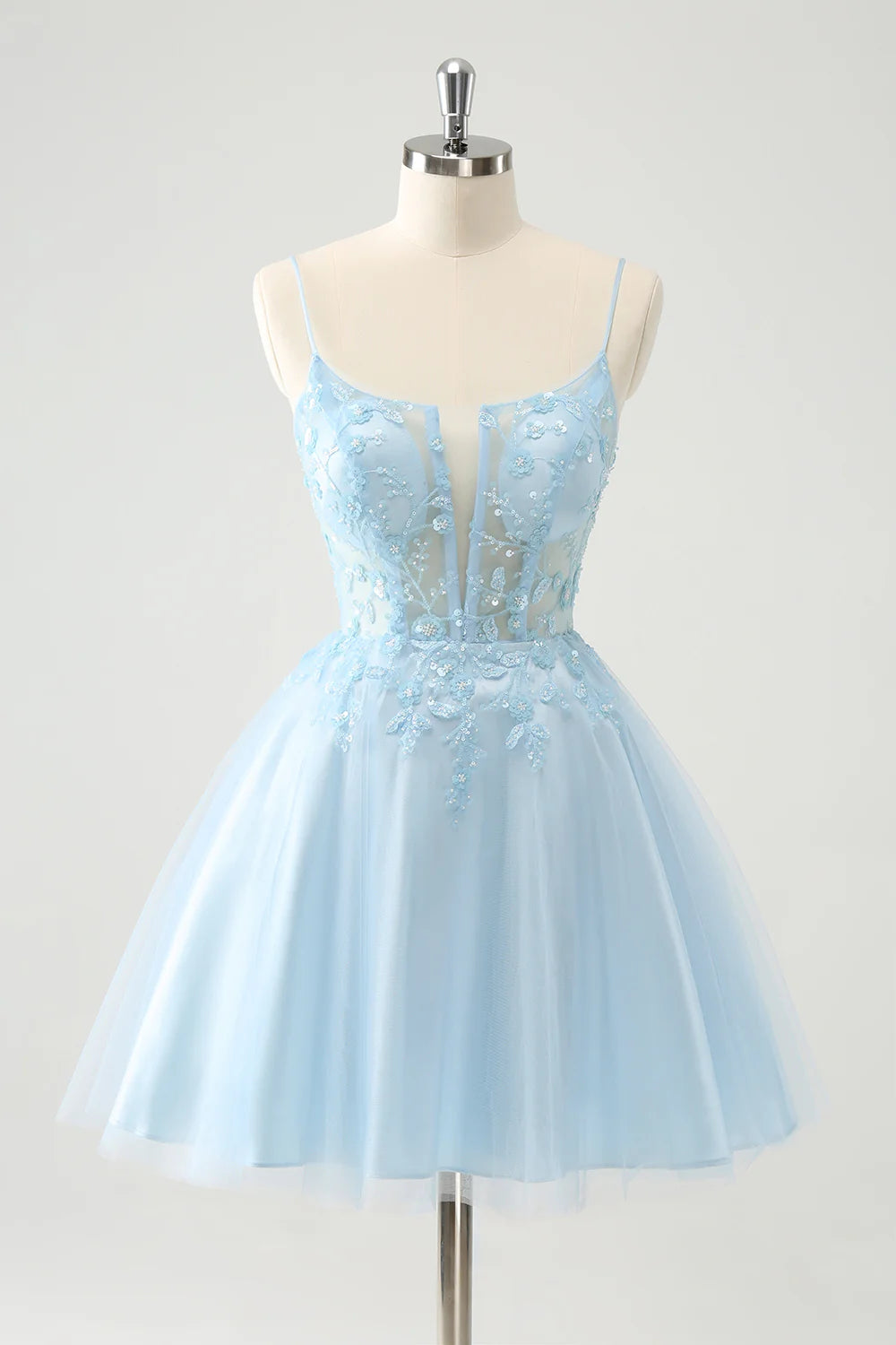Model wearing a sparkly blue A-line short homecoming dress with a sweetheart corset and lace-up back.