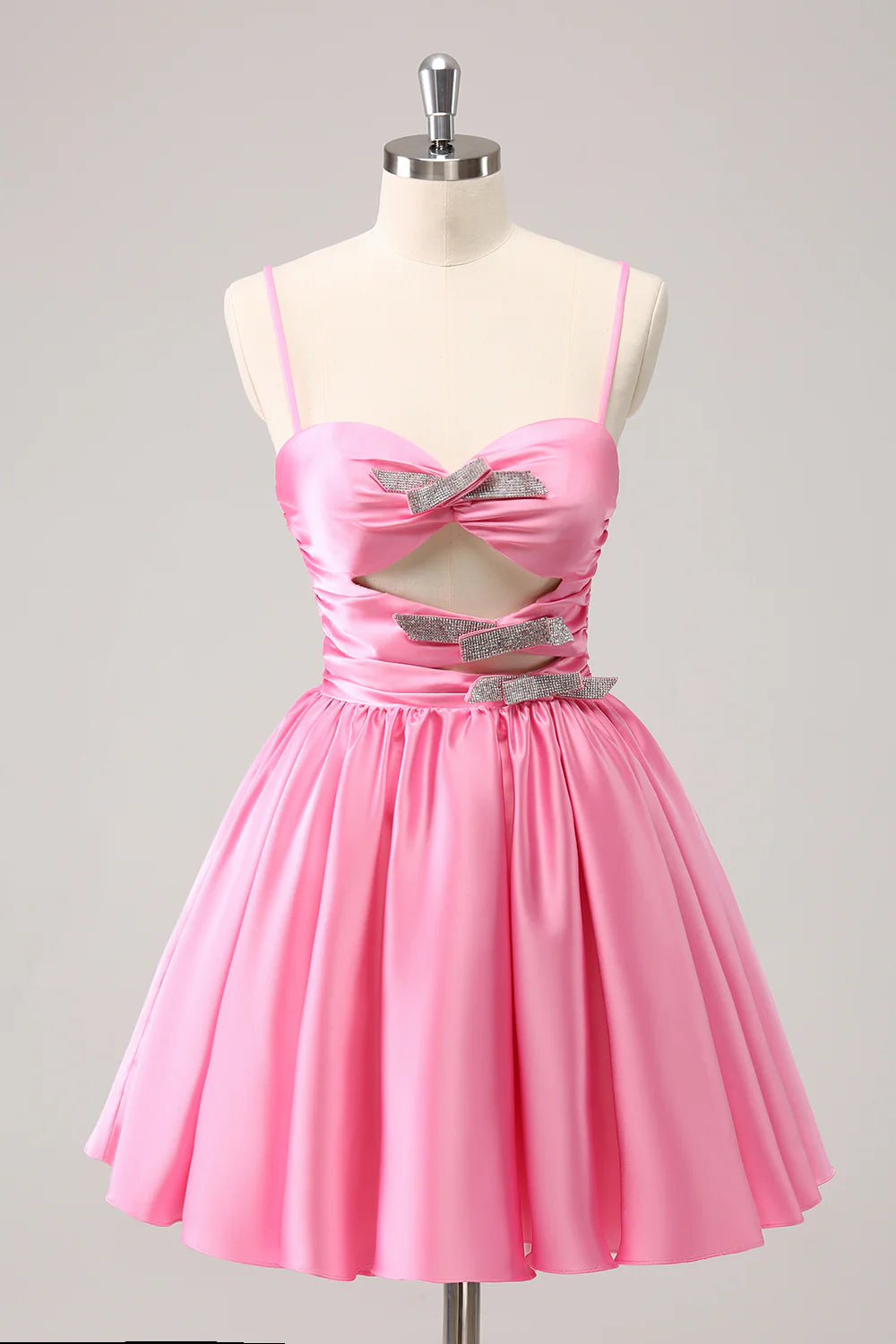 Front view of a sparkly pink A-line homecoming dress with spaghetti straps, cut-out detail, and sequin embellishments.