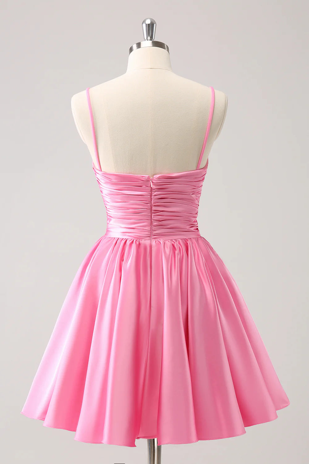 Side view of a model wearing a pink sequin A-line dress with spaghetti straps and a cut-out waist.