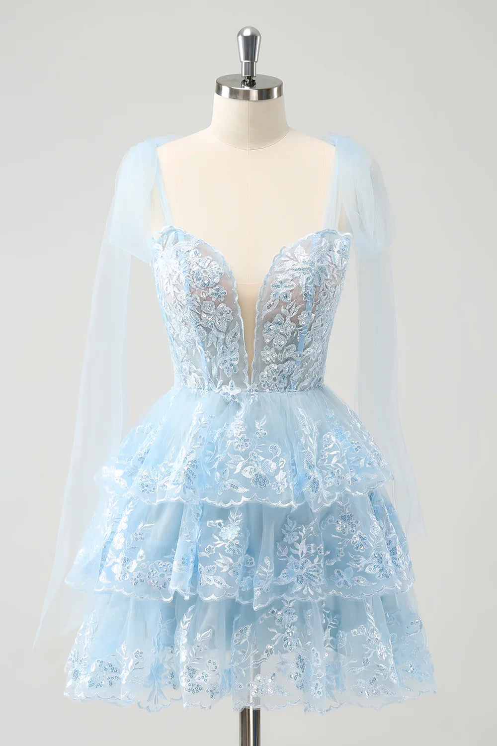 Model wearing a sparkly blue A-line V-neck short homecoming dress.