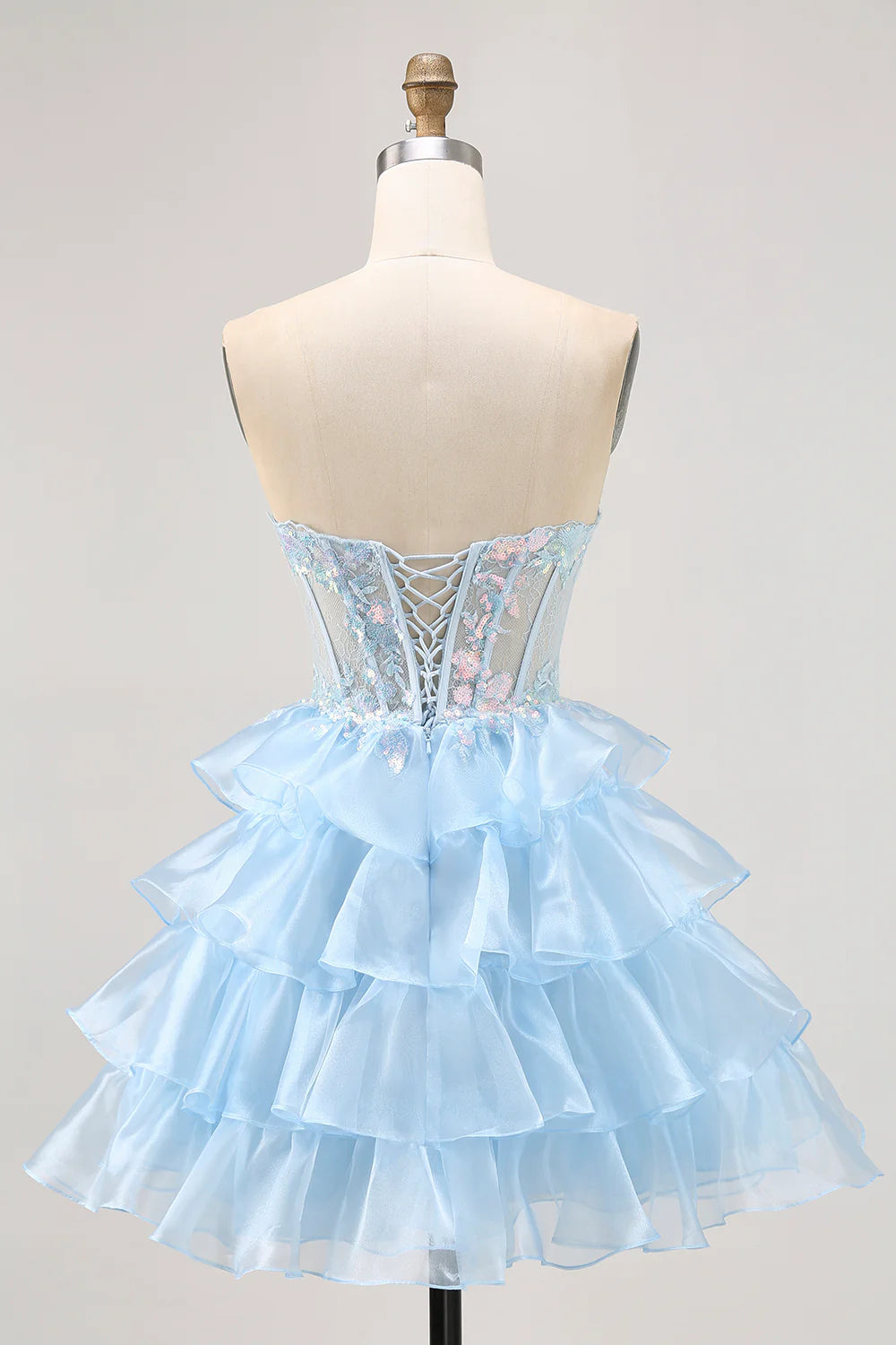 Back view of a sparkly blue A-line short dress with sequin embellishments.