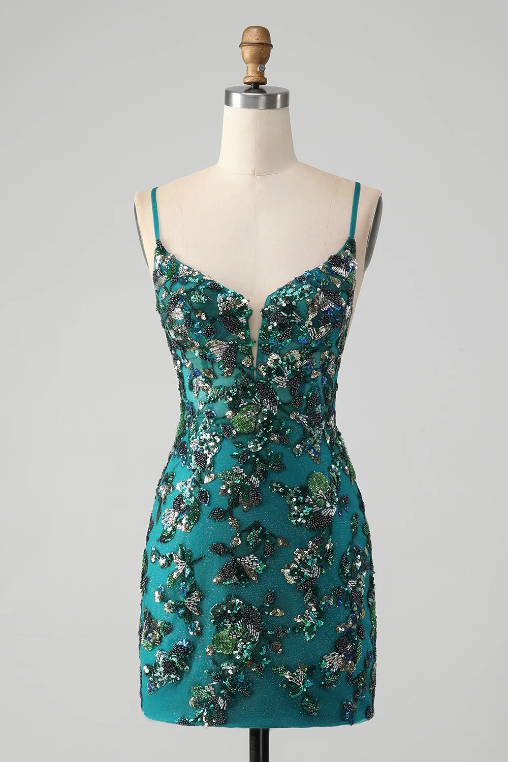 Model wearing a sparkly dark green bodycon homecoming dress with spaghetti straps and beading.