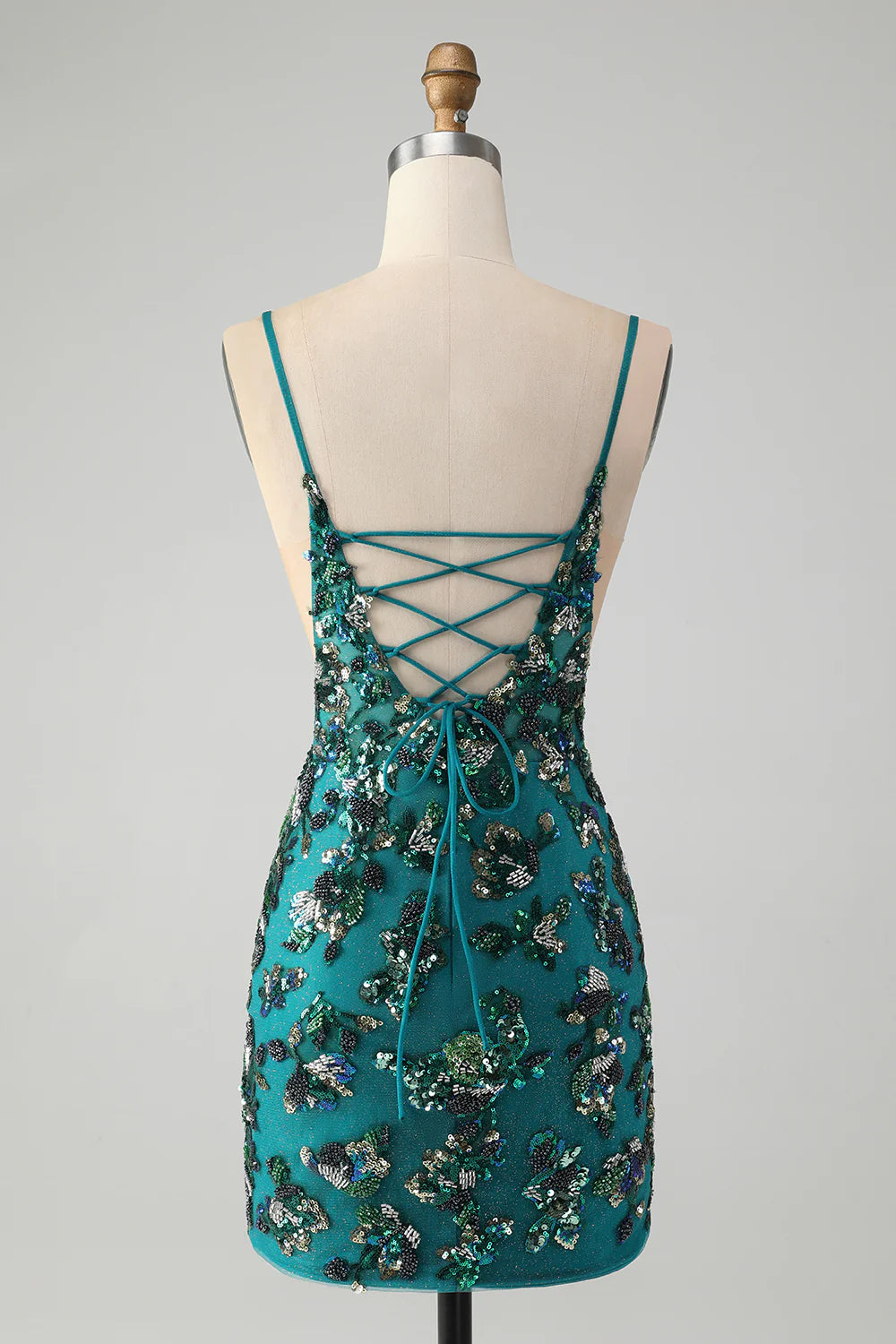 Back view of a model in a sparkly dark green bodycon dress, showing beaded details.