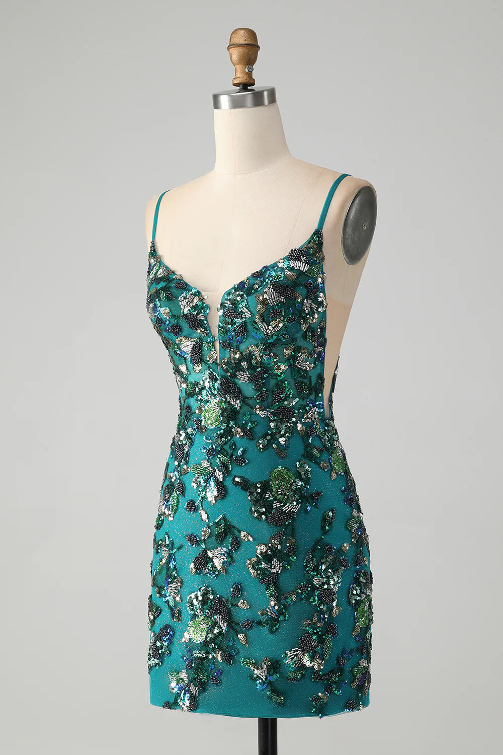Side view of a model in a short sparkly dark green bodycon dress.