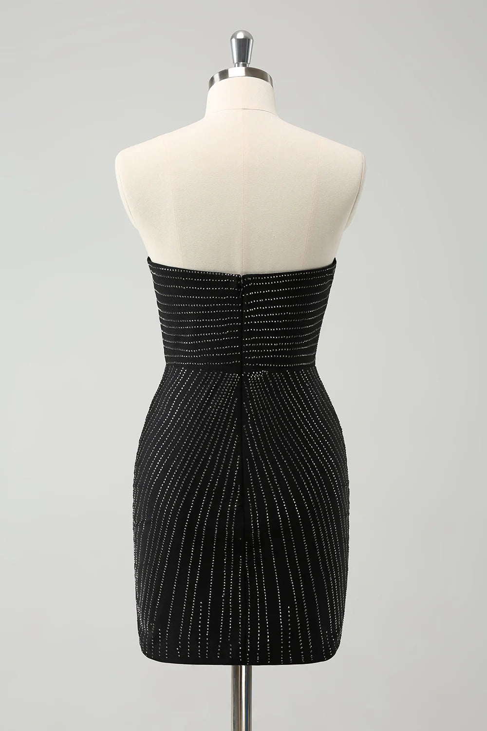 Model wearing a sparkly black strapless short homecoming dress, side view.
