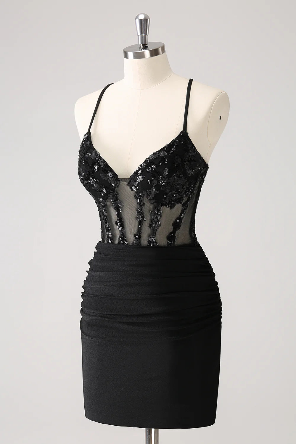 Side view of a model in a tight-fitting black sequin spaghetti strap dress.