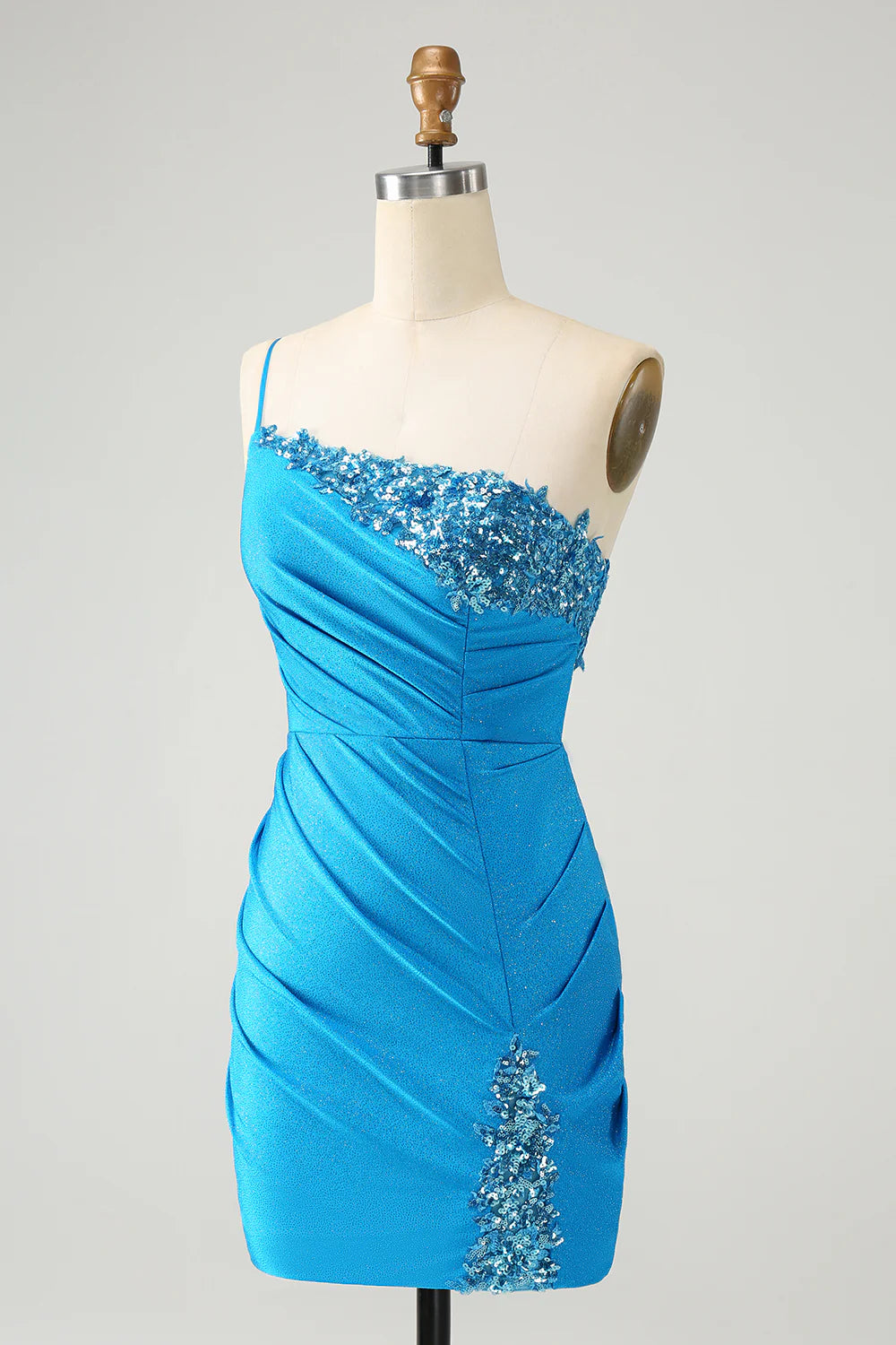 Close-up of the sparkly blue fabric and pleated detail on the one-shoulder dress.