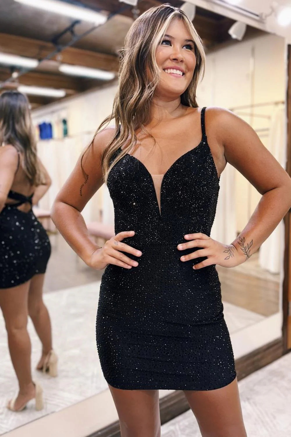 Sparkly black bodycon homecoming dress with spaghetti straps and beading.