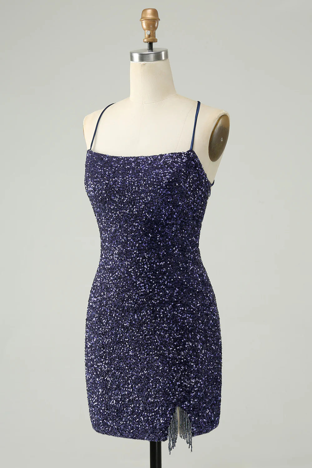 Side view of short navy sparkly dress with backless design.