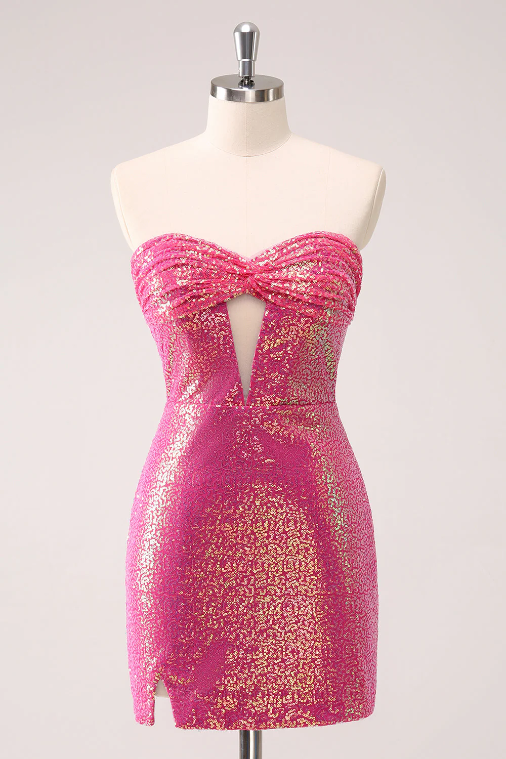 Model wearing a sparkly fuchsia bodycon strapless short homecoming dress with a side slit.
