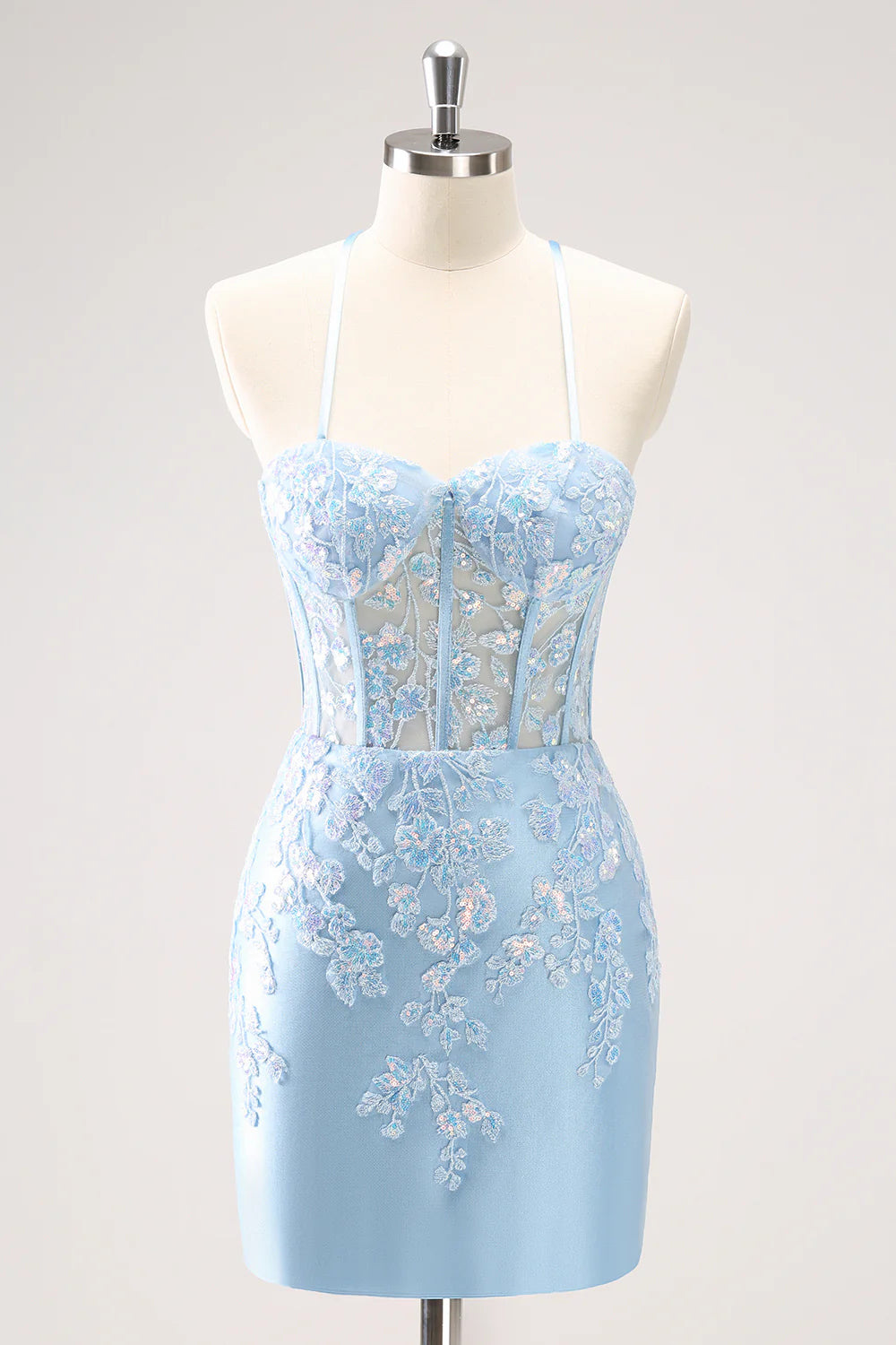 Model wearing a sparkly blue bodycon spaghetti strap sequin dress with appliques.
