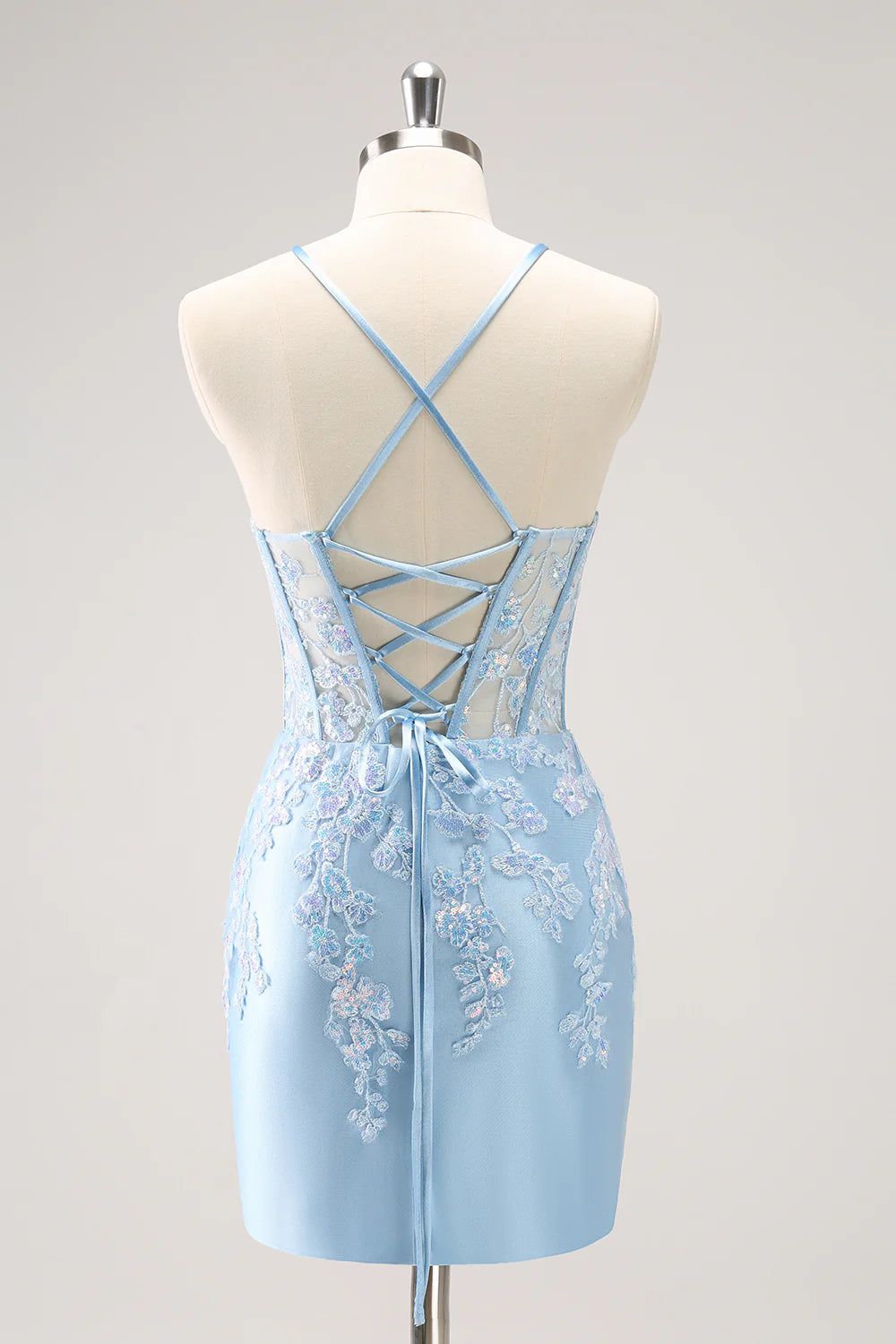 Close-up of a sparkly blue bodycon spaghetti strap sequin dress with appliques.