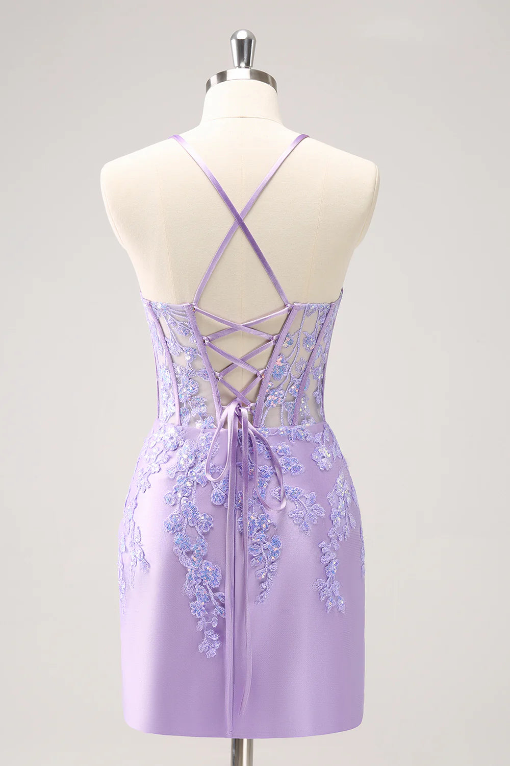 Close-up of a sparkly lilac bodycon spaghetti strap sequin dress with appliques.