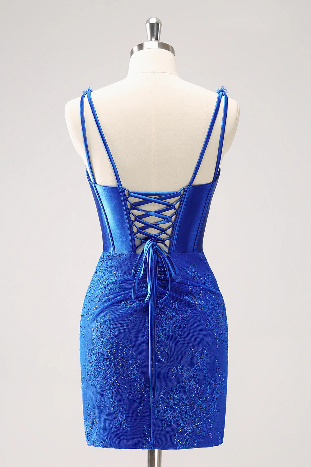 Back view of royal blue bodycon dress showing lace-up detail and ruched skirt.