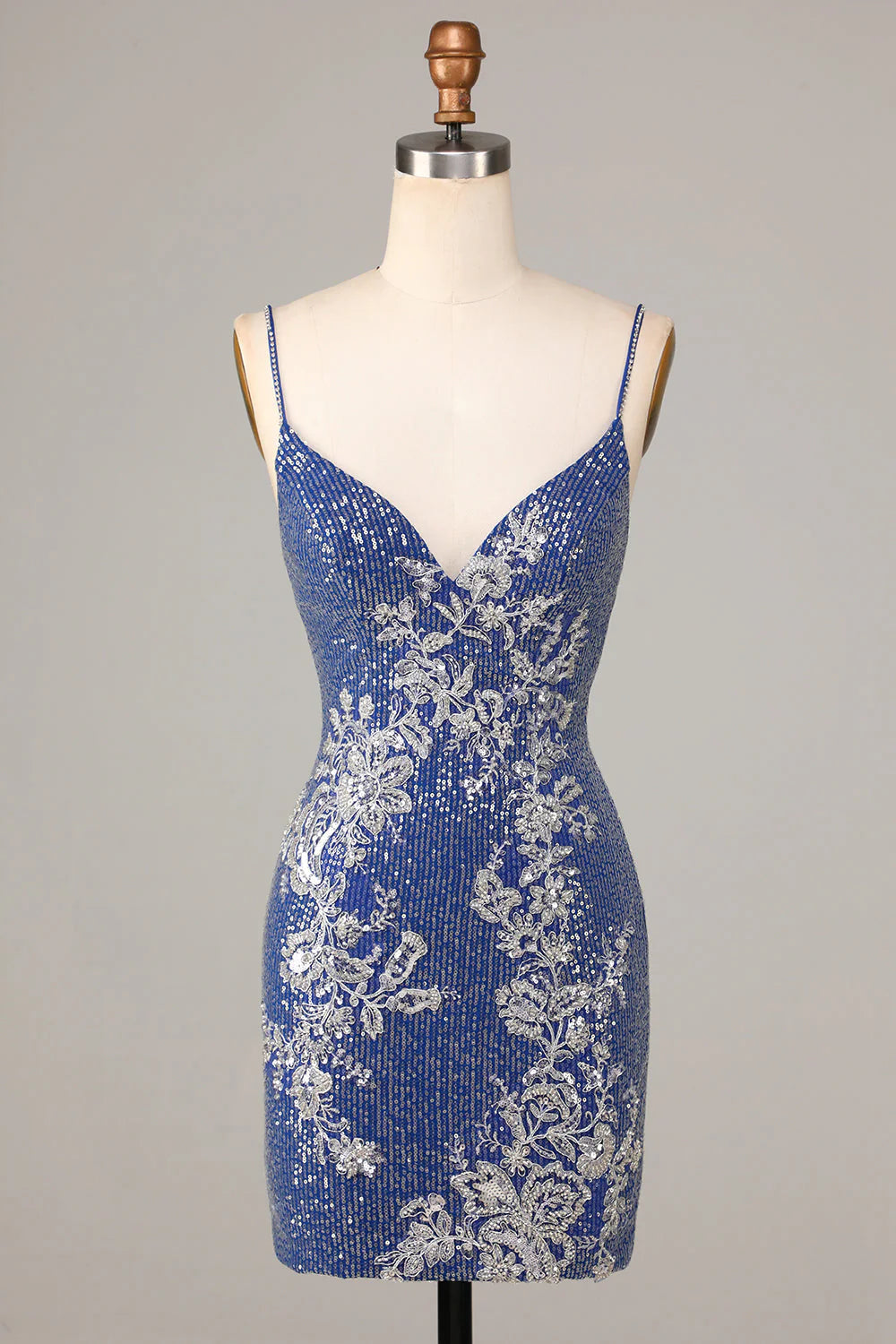 Model wearing a sparkly dark blue sheath homecoming dress with spaghetti straps and sequins.