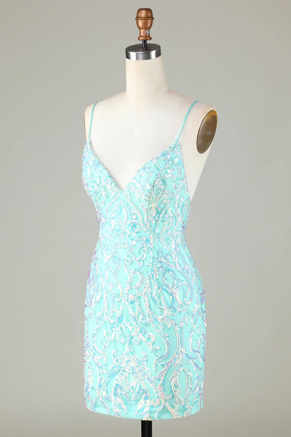 Side view of a fitted sparkly green spaghetti strap dress.