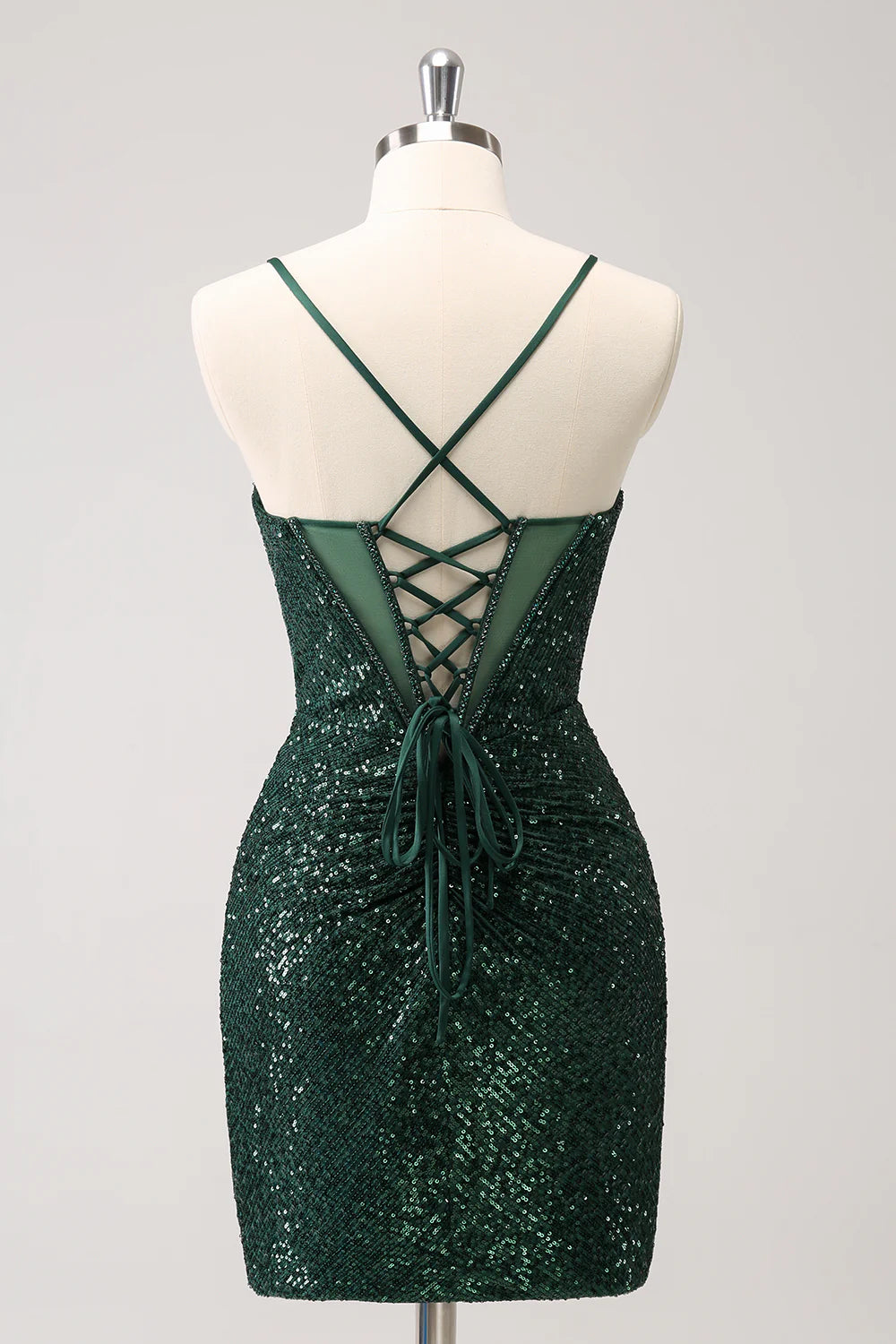 Back view of a model in a dark green sequin homecoming dress showing the lace-up detail.