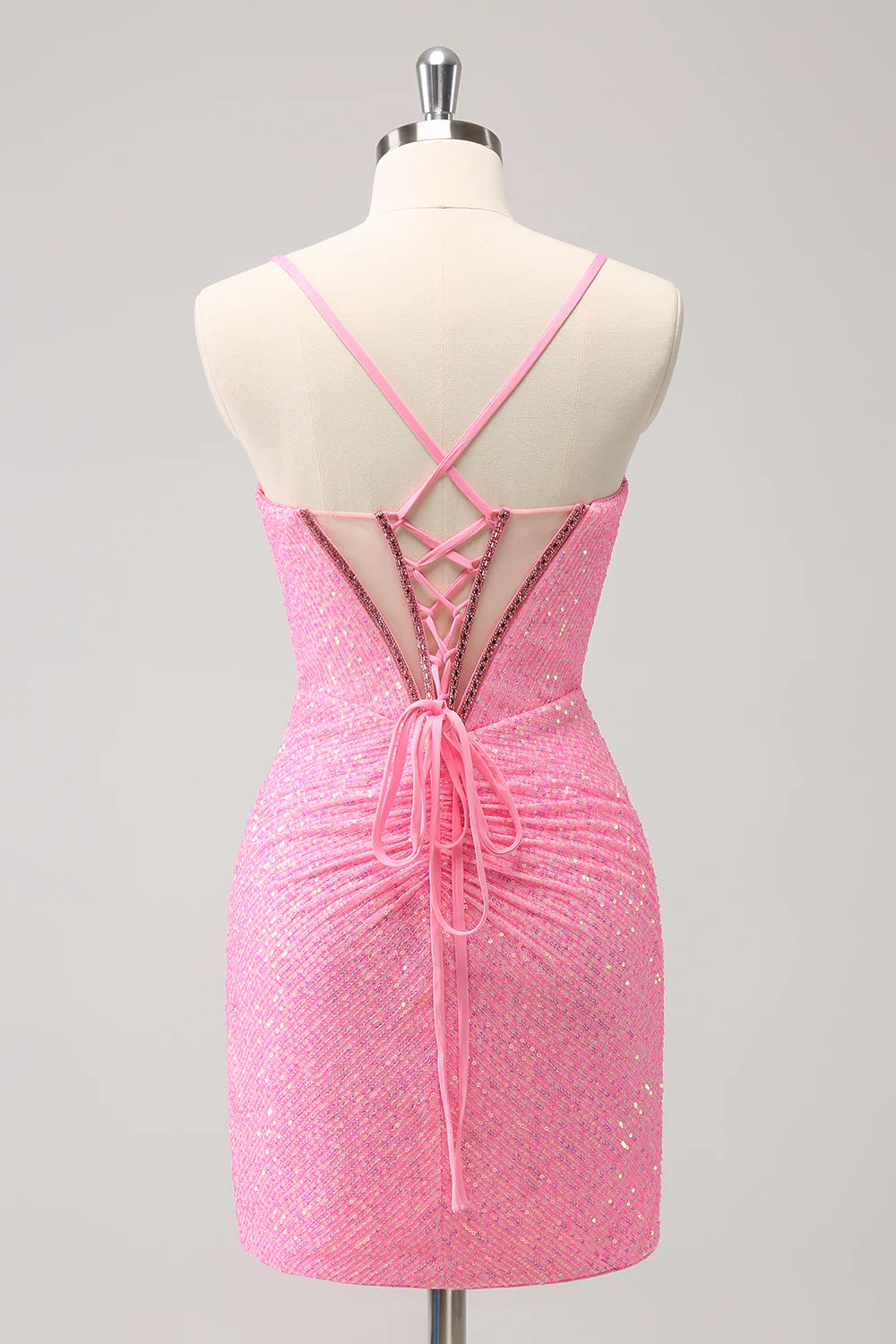 Back view of a model in a hot pink sequin homecoming dress showing the lace-up detail.