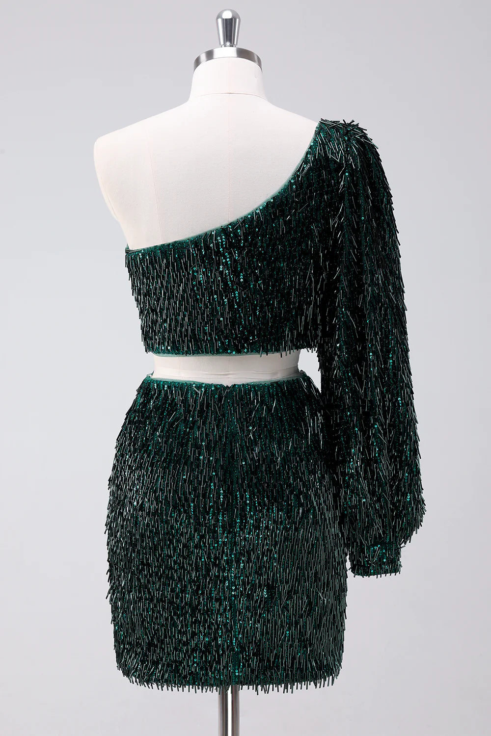Close-up of the sparkly fringed detail on the dark green one-shoulder homecoming dress.