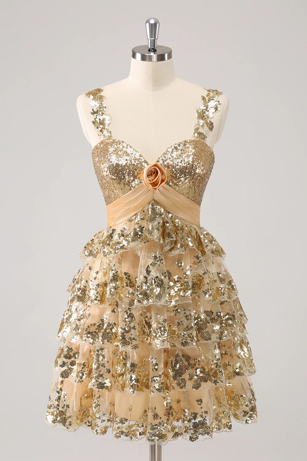 Model wearing a sparkly golden A-line short homecoming dress with a corset bodice and flower detail.