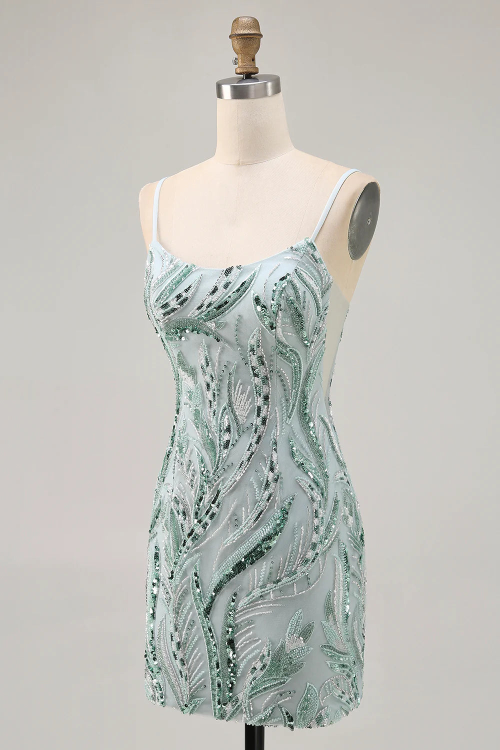 Side view of a woman wearing a sparkly green bodycon short homecoming dress with sequins and beading.