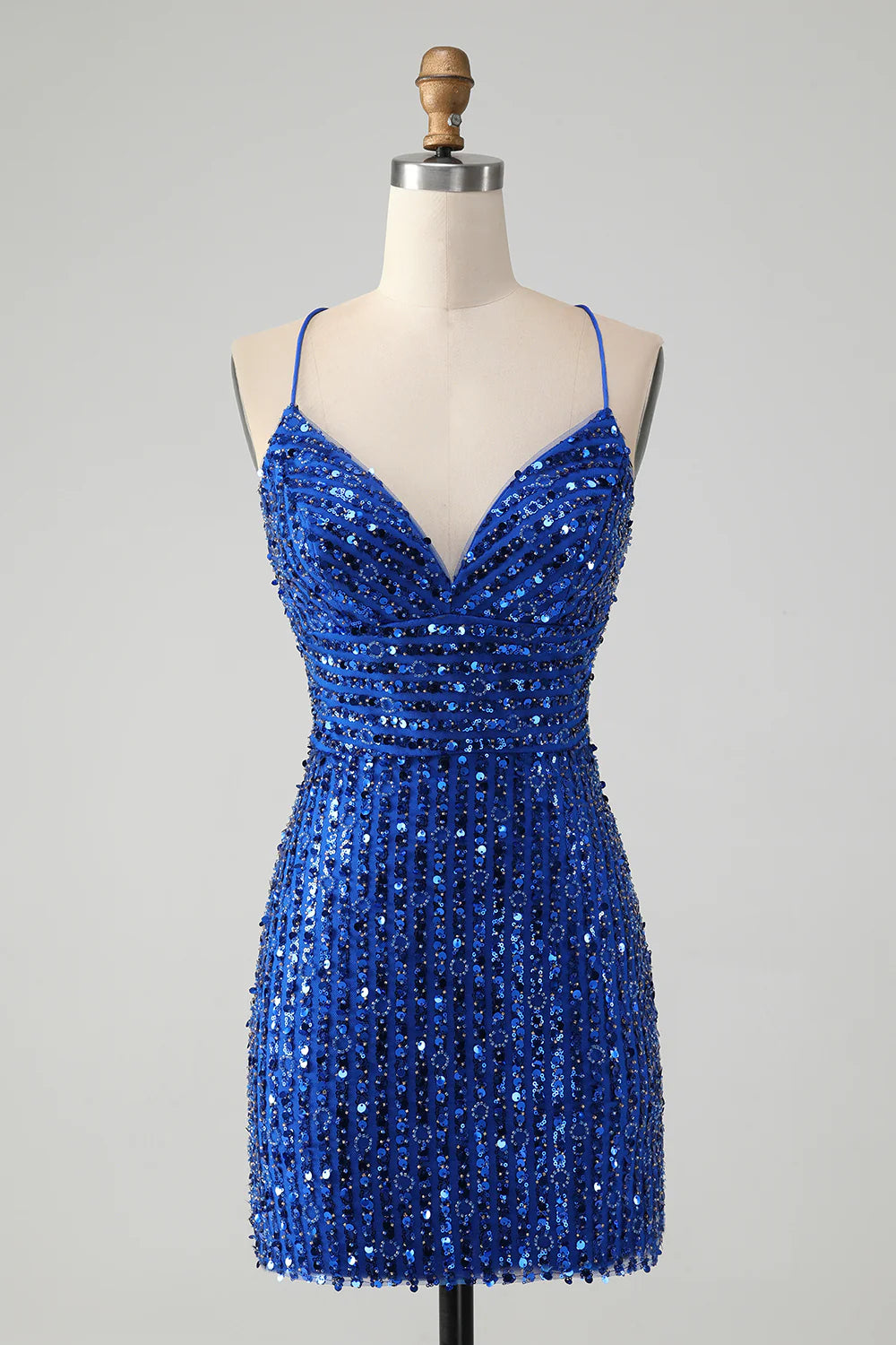 Model wearing a sparkly royal blue sheath homecoming dress with a criss-cross back.
