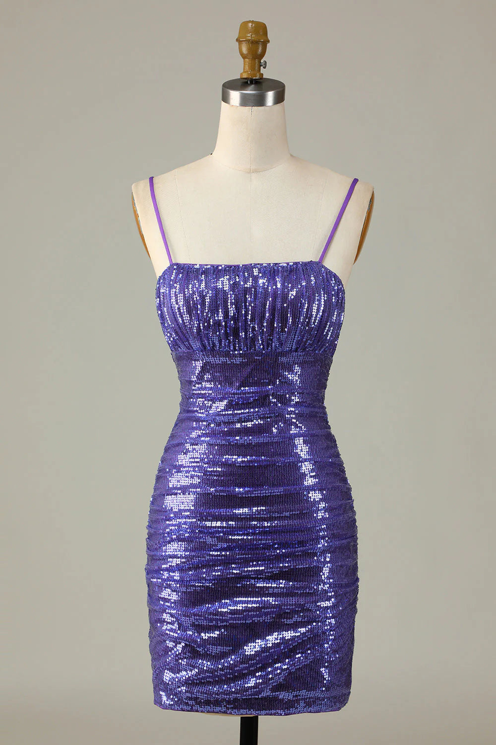 Model wearing a sparkly purple sequin short homecoming dress with spaghetti straps.