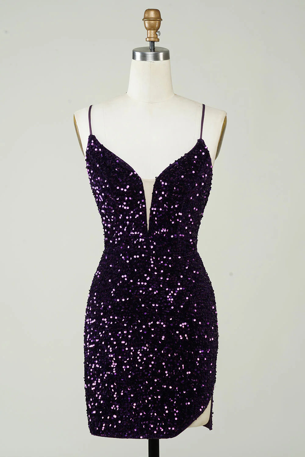 Front view of a model wearing a sparkly purple sequin sheath homecoming dress with a high slit.