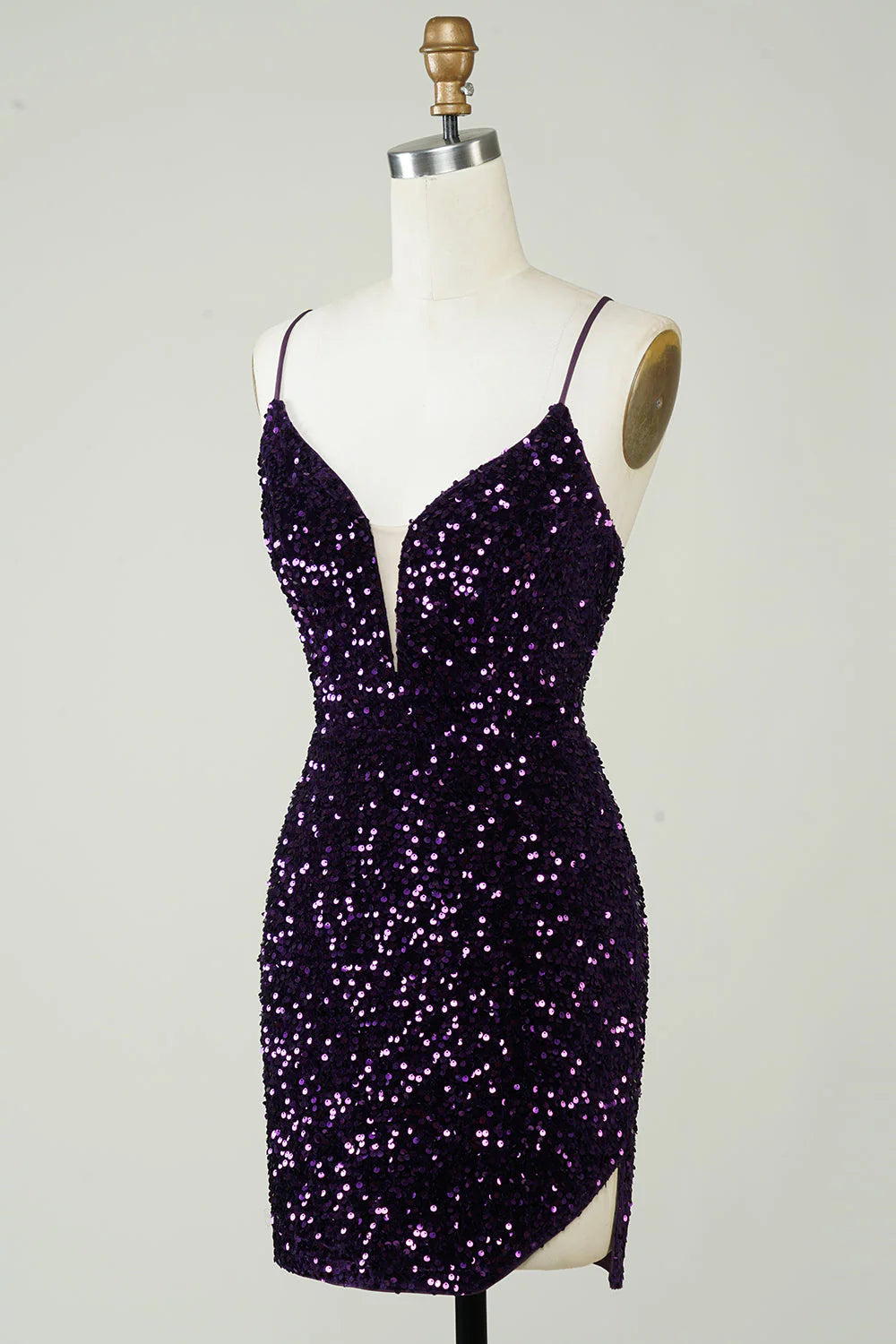 Back view of a model showcasing the backless design of a short purple sequin dress.
