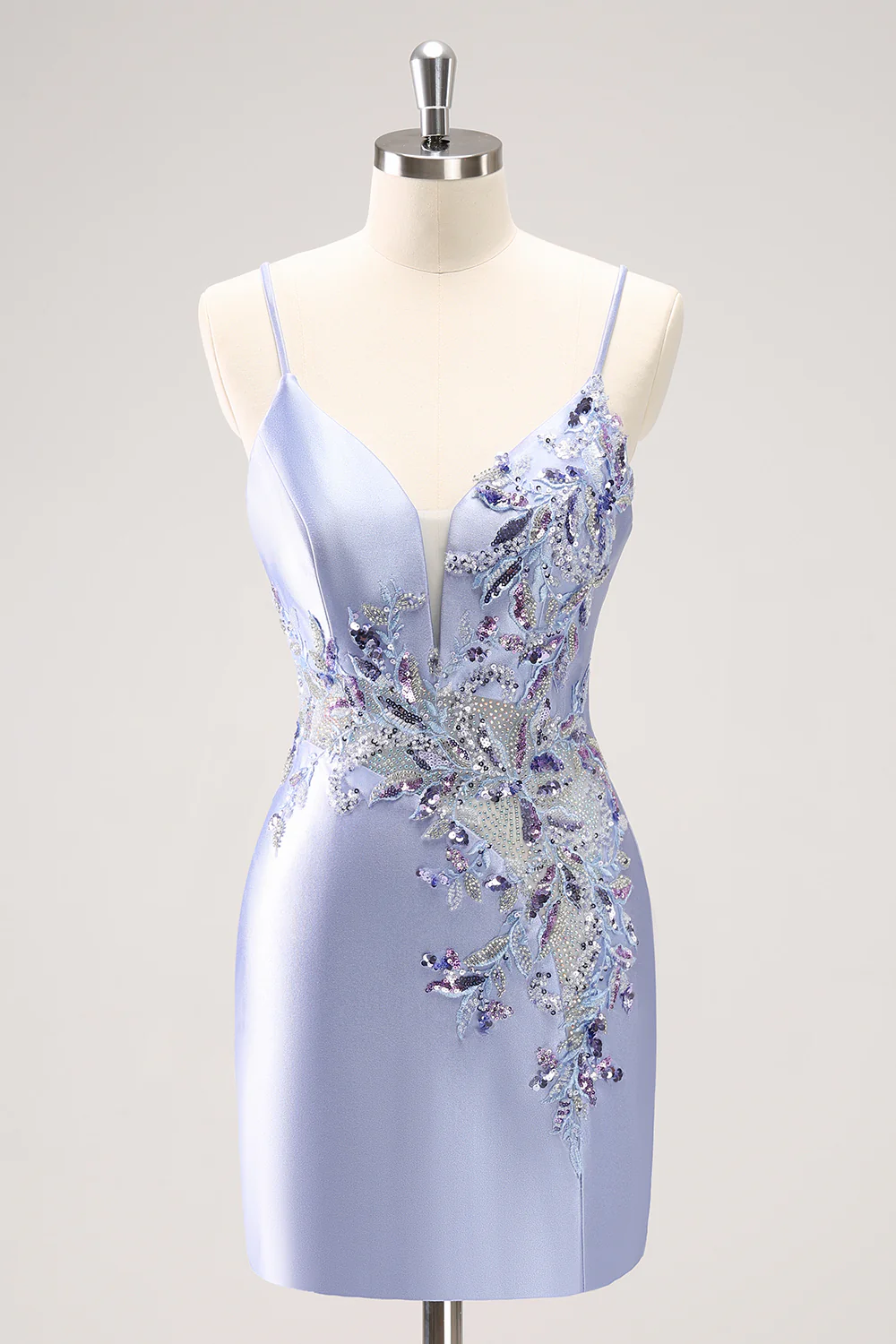 Model posing in a sparkly blue sequin homecoming dress with spaghetti straps and beading.