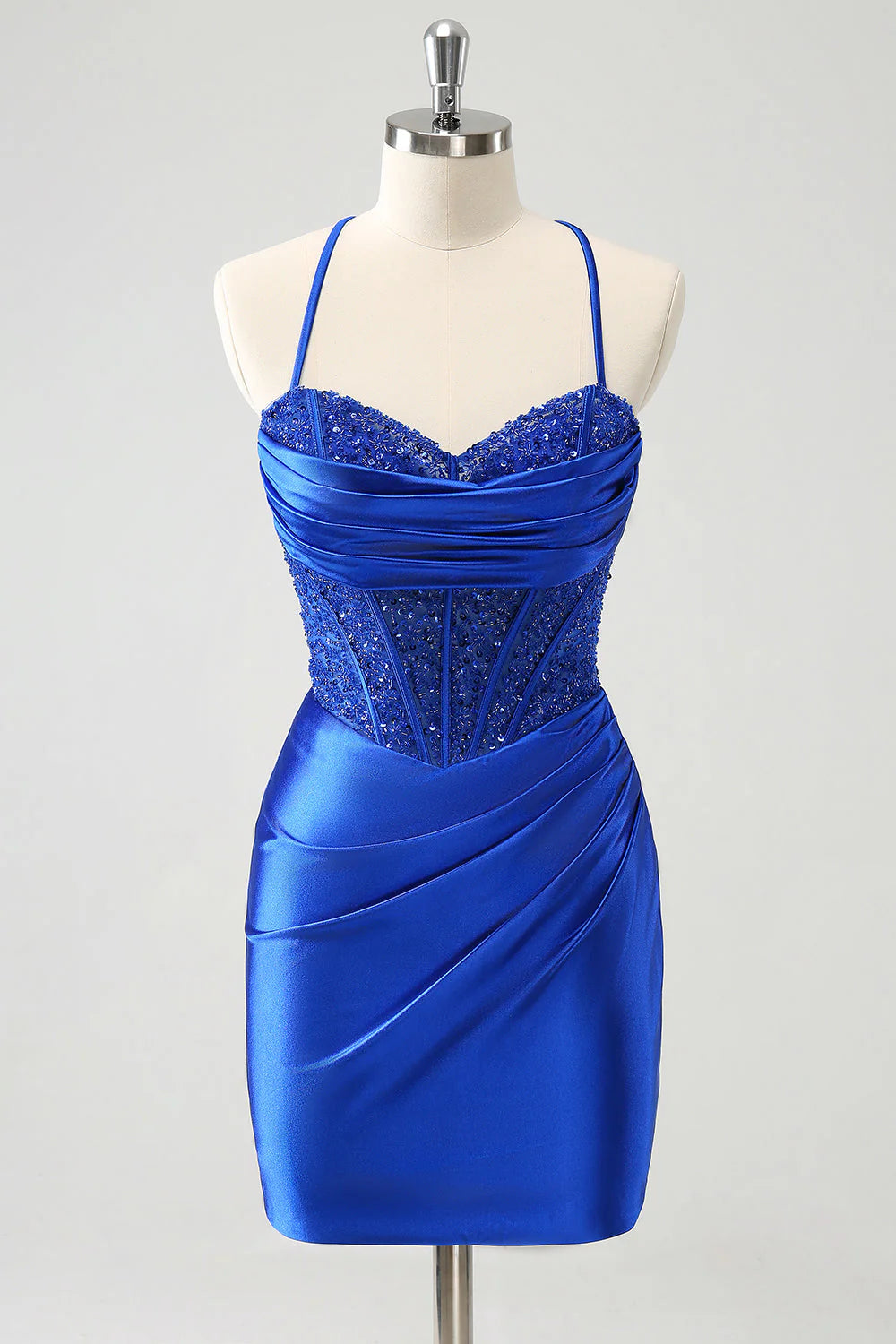 Model wearing a sparkly royal blue sequin pleated short homecoming dress with a strapless corset bodice.