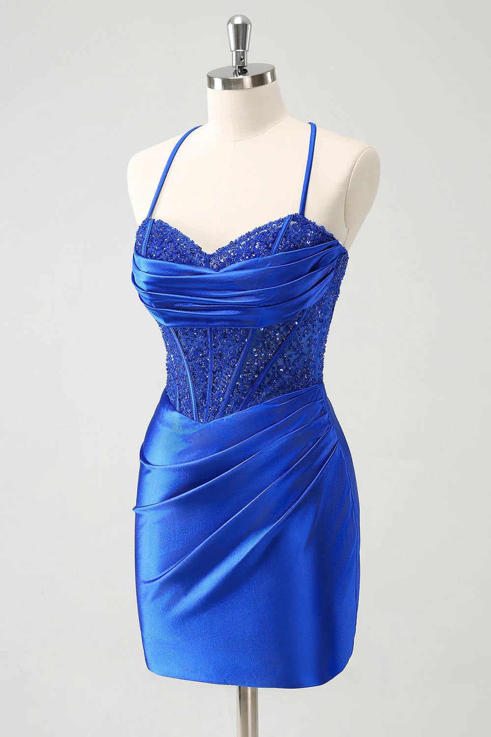 Close-up of the sparkly royal blue sequin fabric and pleated detail on a short homecoming dress.