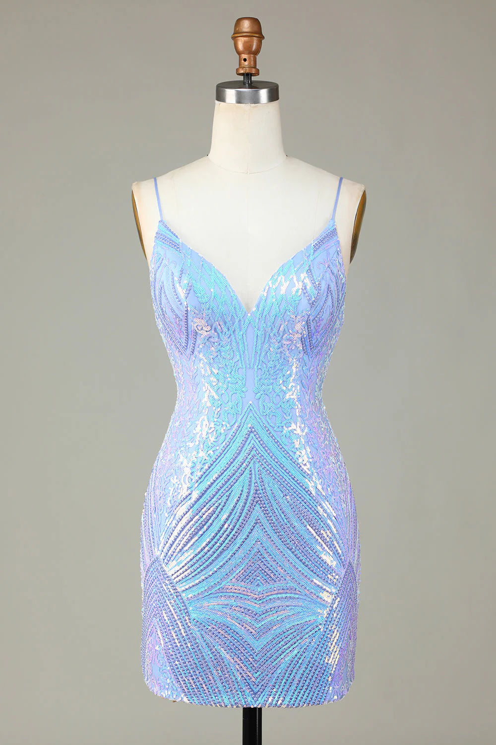 Model wearing a sparkly blue sequin sheath short homecoming dress with spaghetti straps and a backless design.