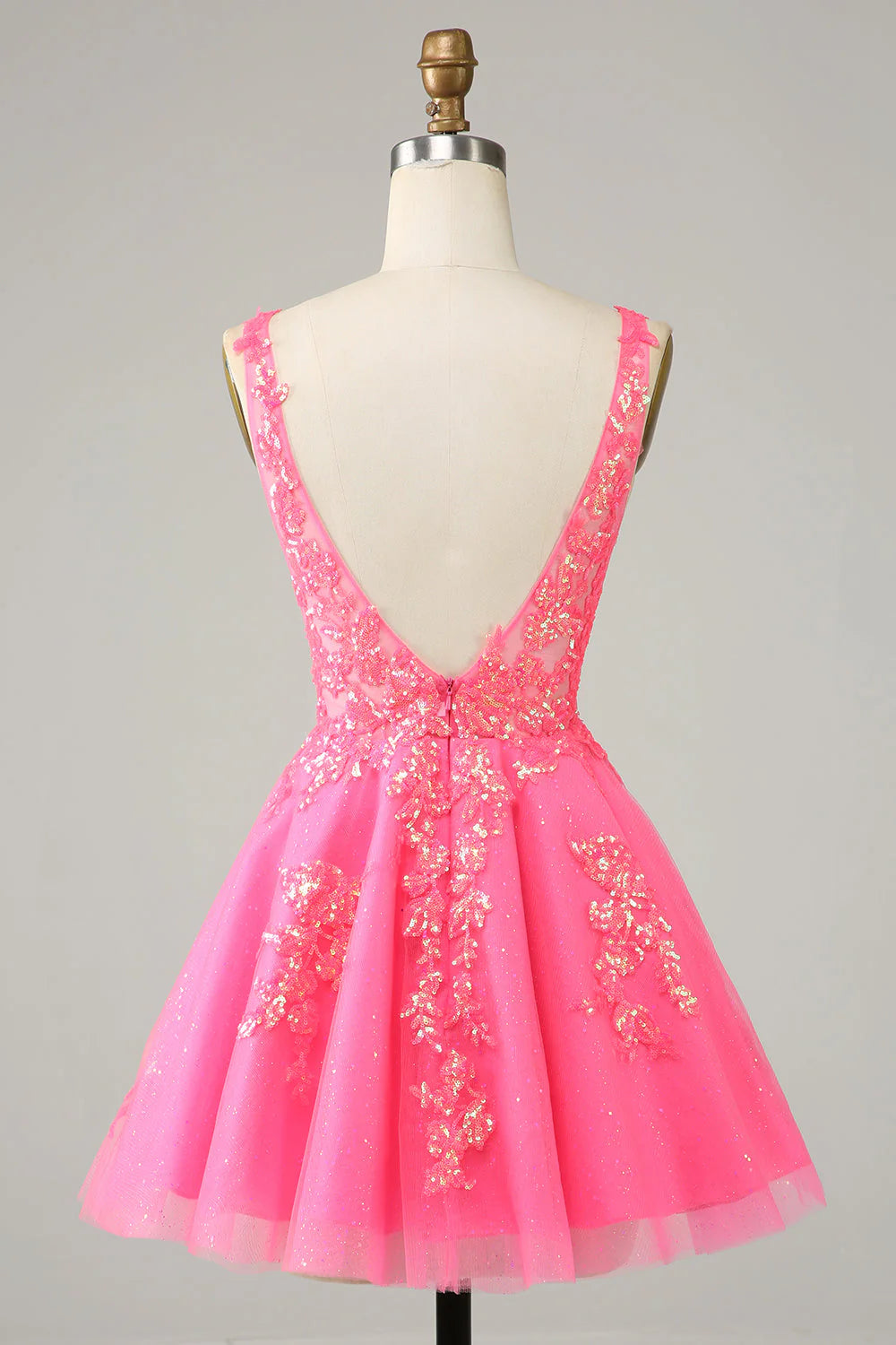 Back view of a sparkly fuchsia sequined short homecoming dress with backless detail.