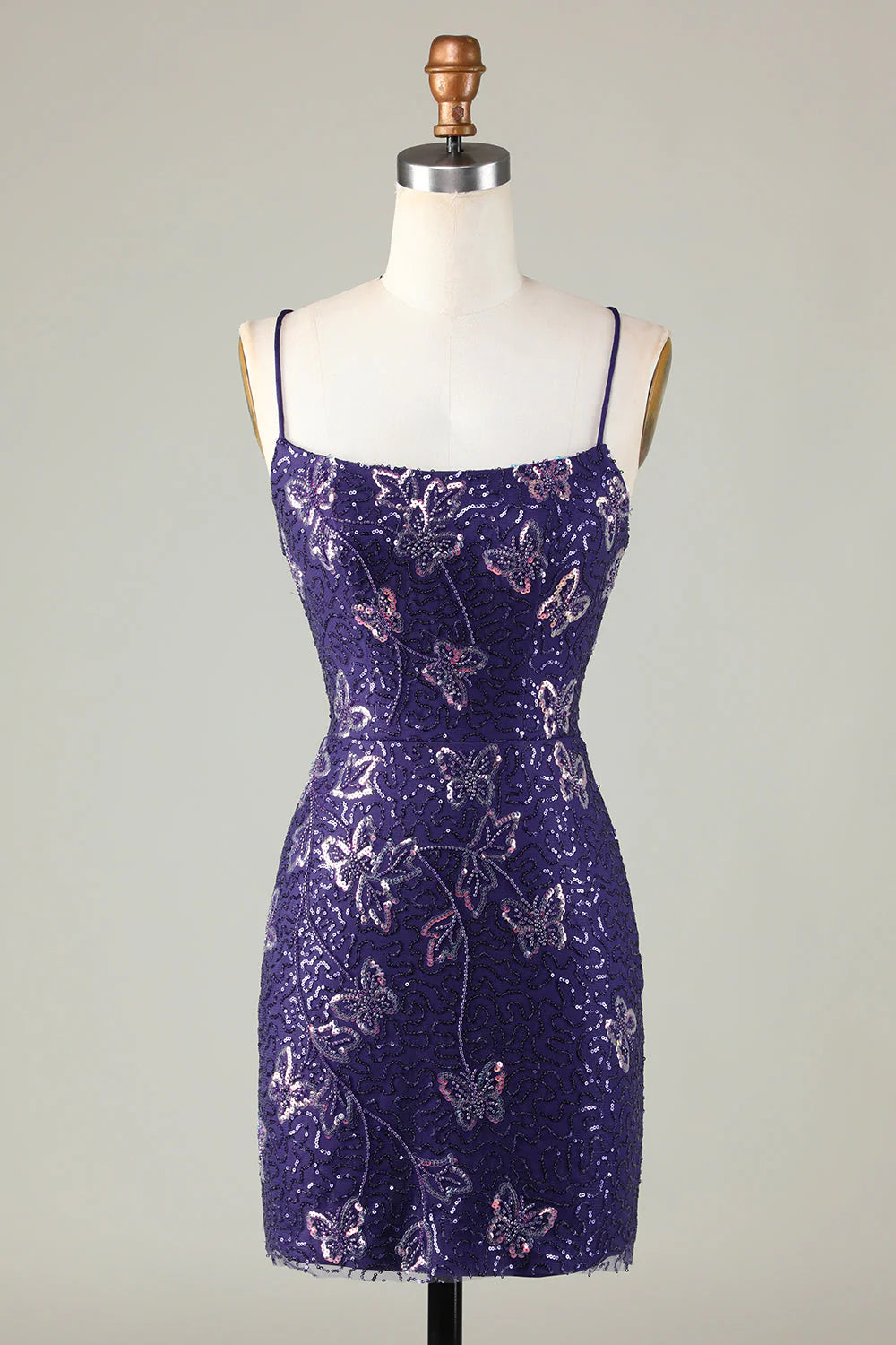Model wearing a sparkly dark purple sheath short homecoming dress with spaghetti straps.