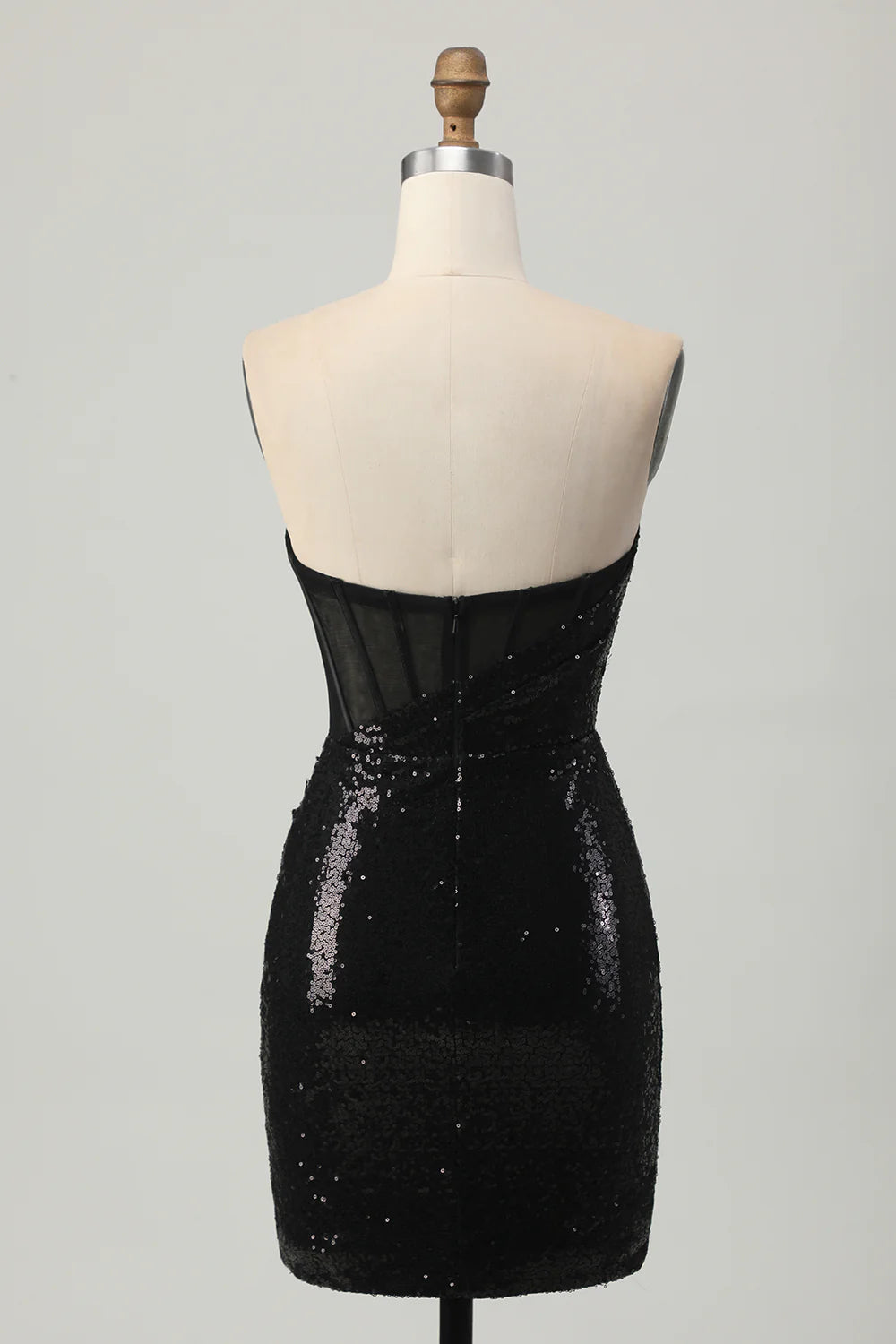 Model wearing a black sequin strapless short dress, side view.