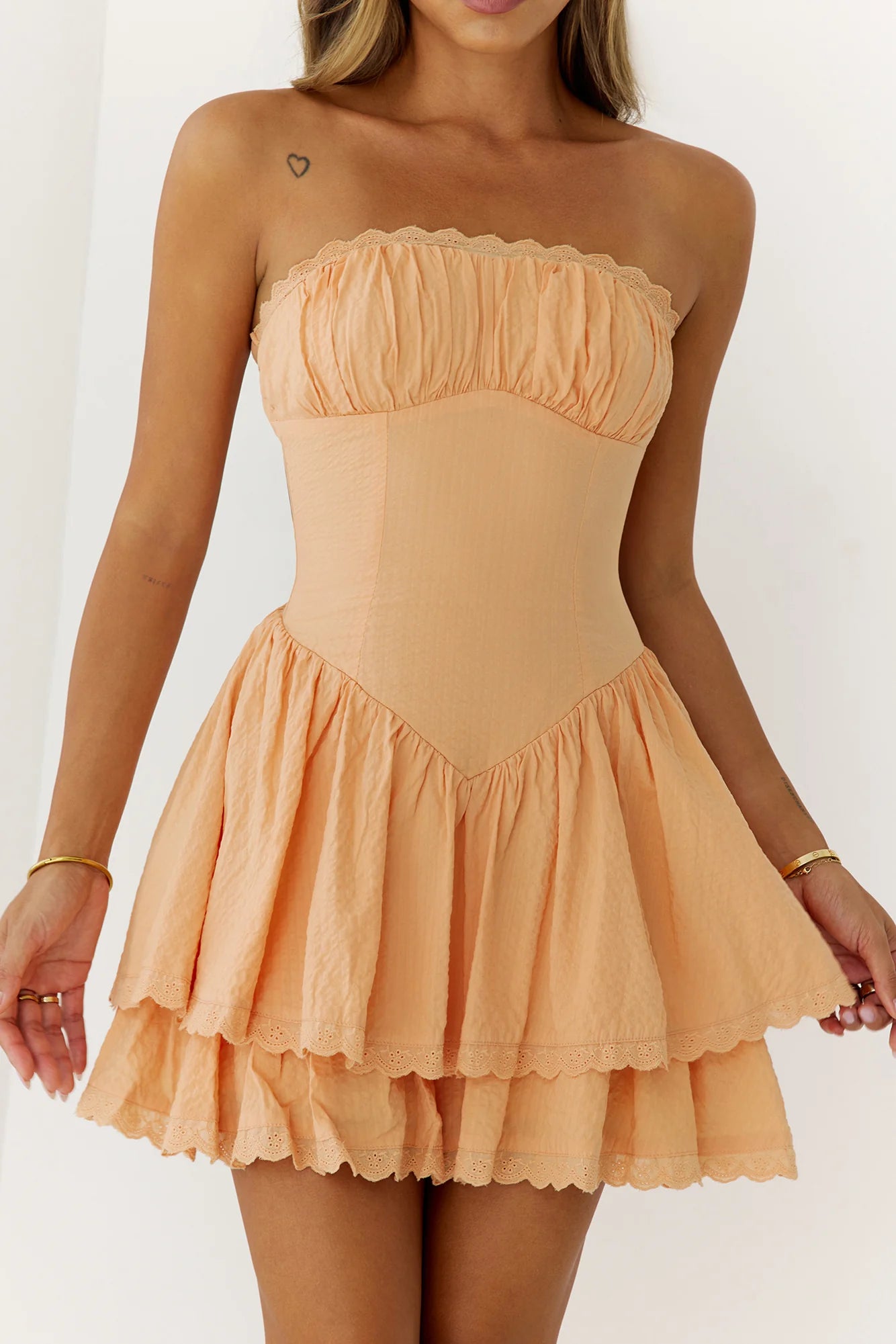 Stunning Peach Strapless Mini Dress with Ruched Bust Detail, V-Waist Accent, Double Layered Lace Trim Skirt and Smocked Back Design