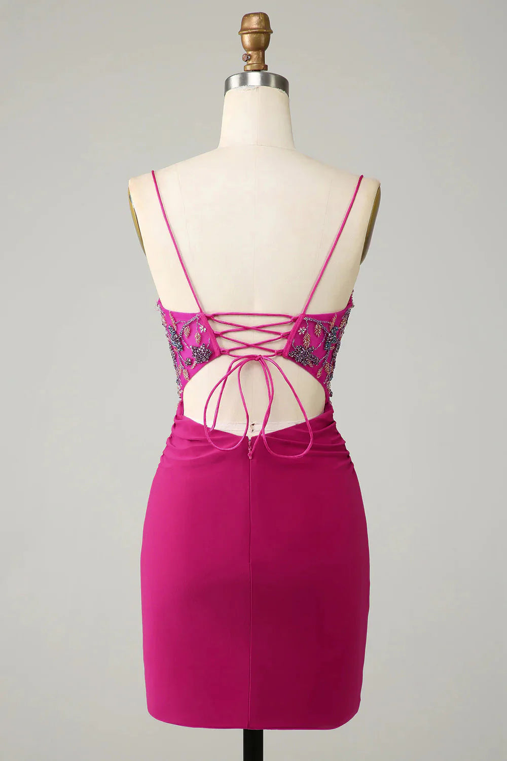 Back view of a fuchsia bodycon short dress with spaghetti straps.