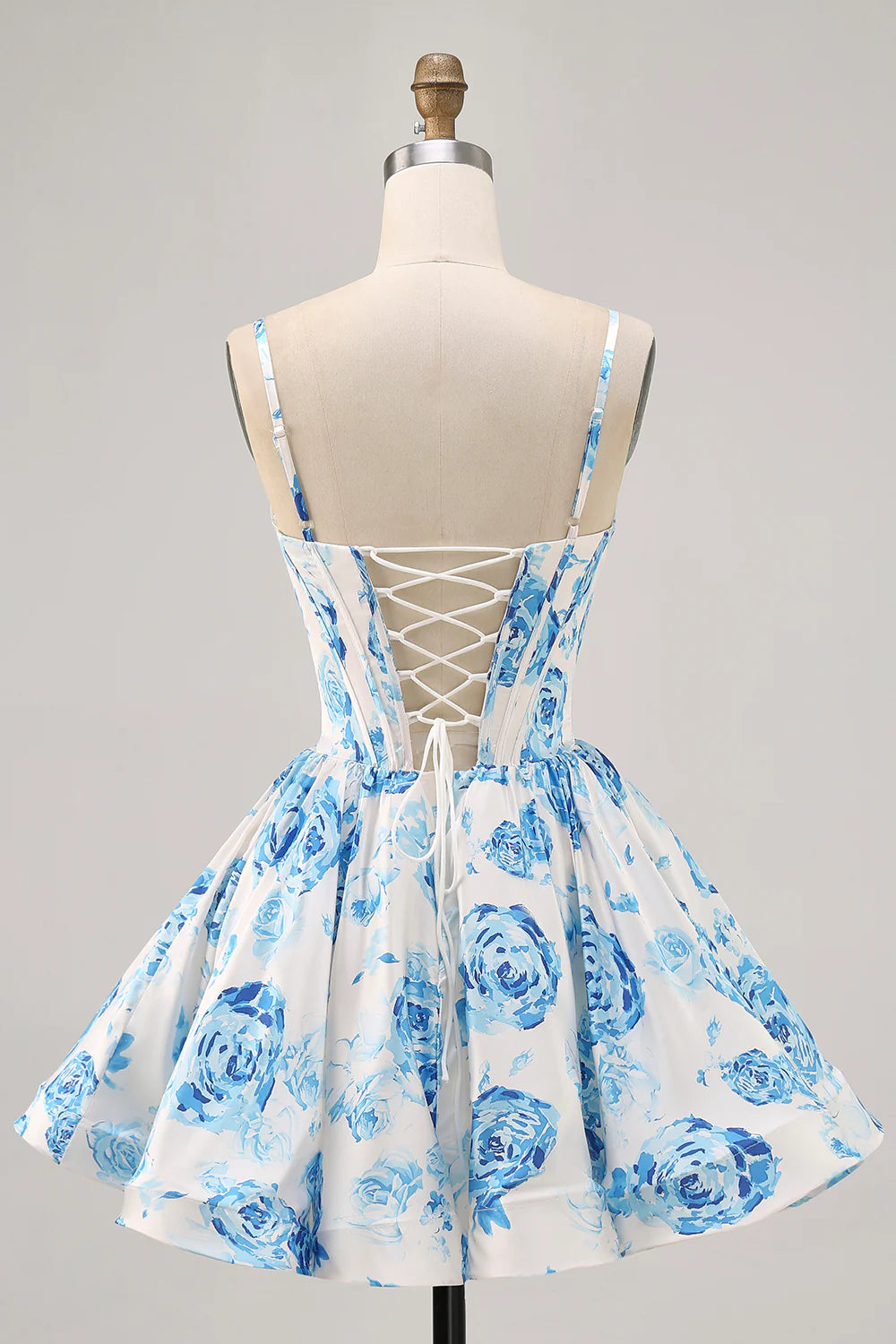 Back view of white and blue floral short homecoming dress showing lace-up detail.